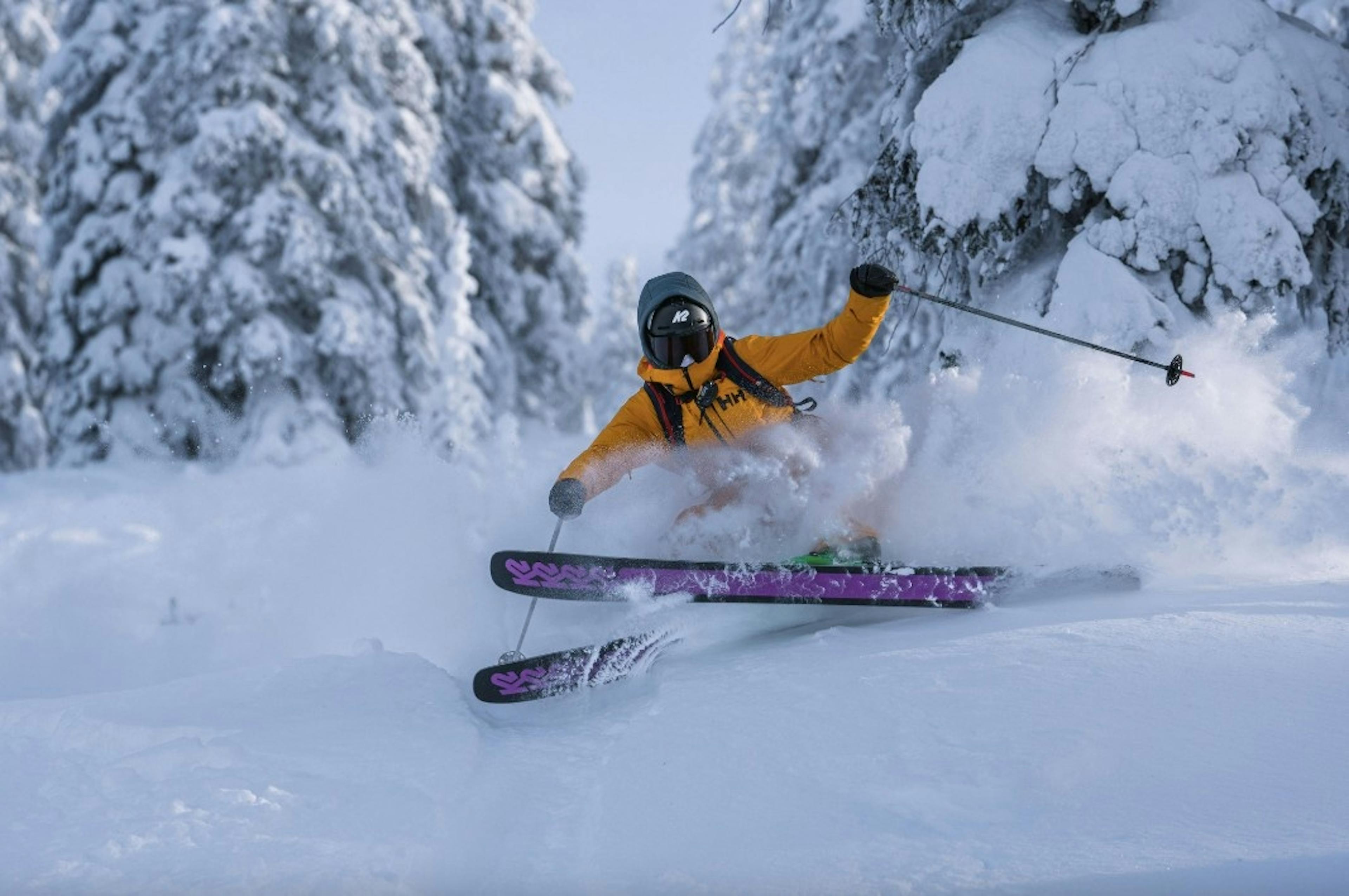 Skier in massive powder while cat skiing at Red Mountain Resort