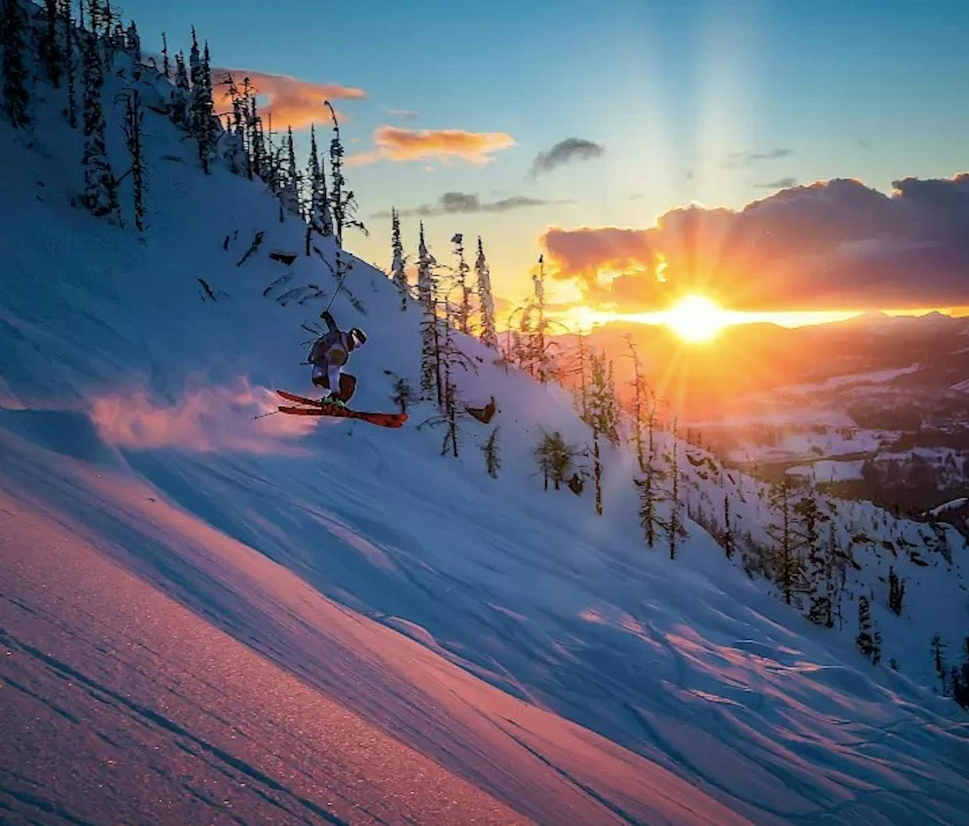 A skier gets some air during sunset at Whitewater ski resort in Canada