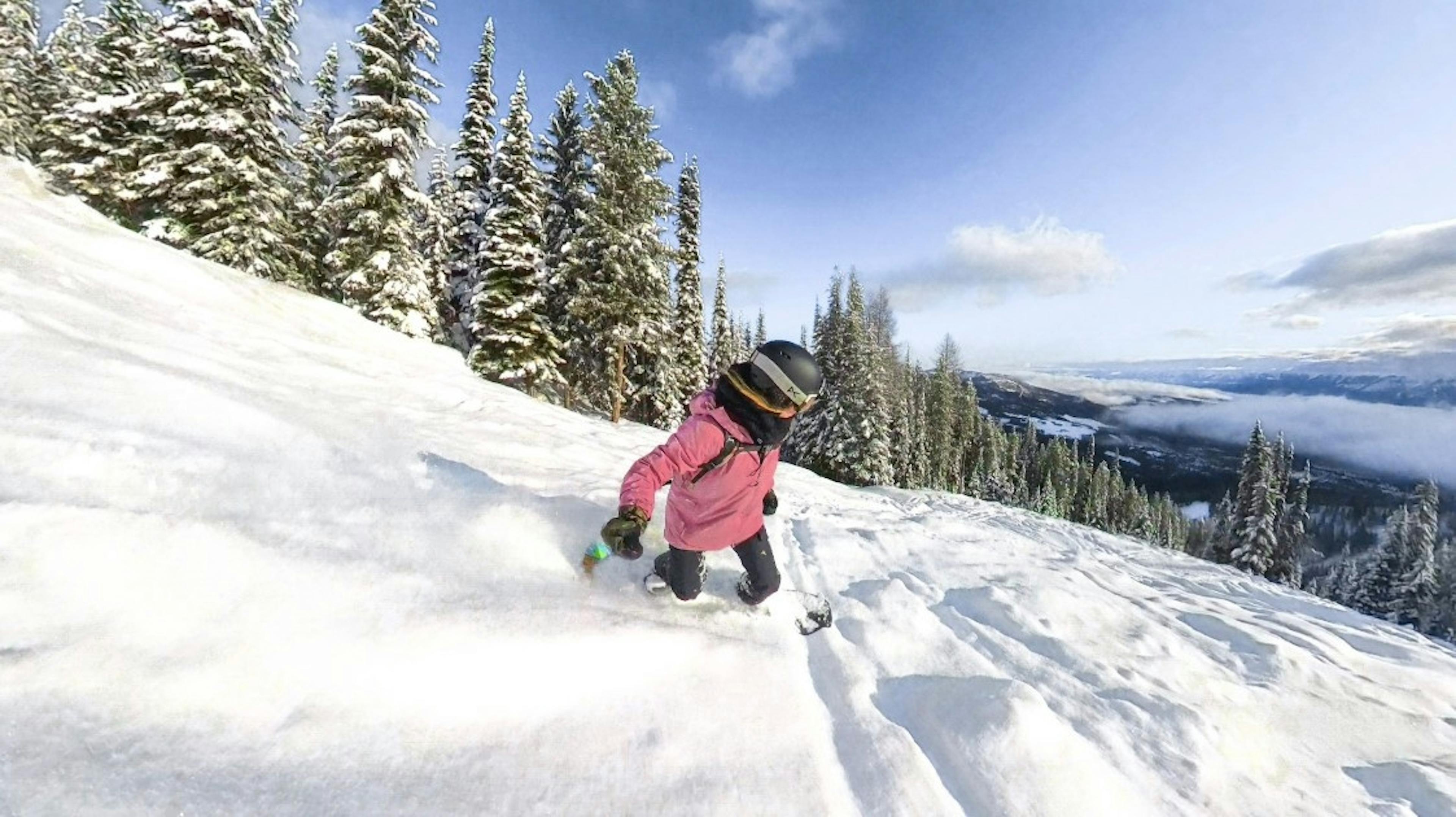 A snowboarder knee deep in powder on the slopes at Kimberley Ski Resort
