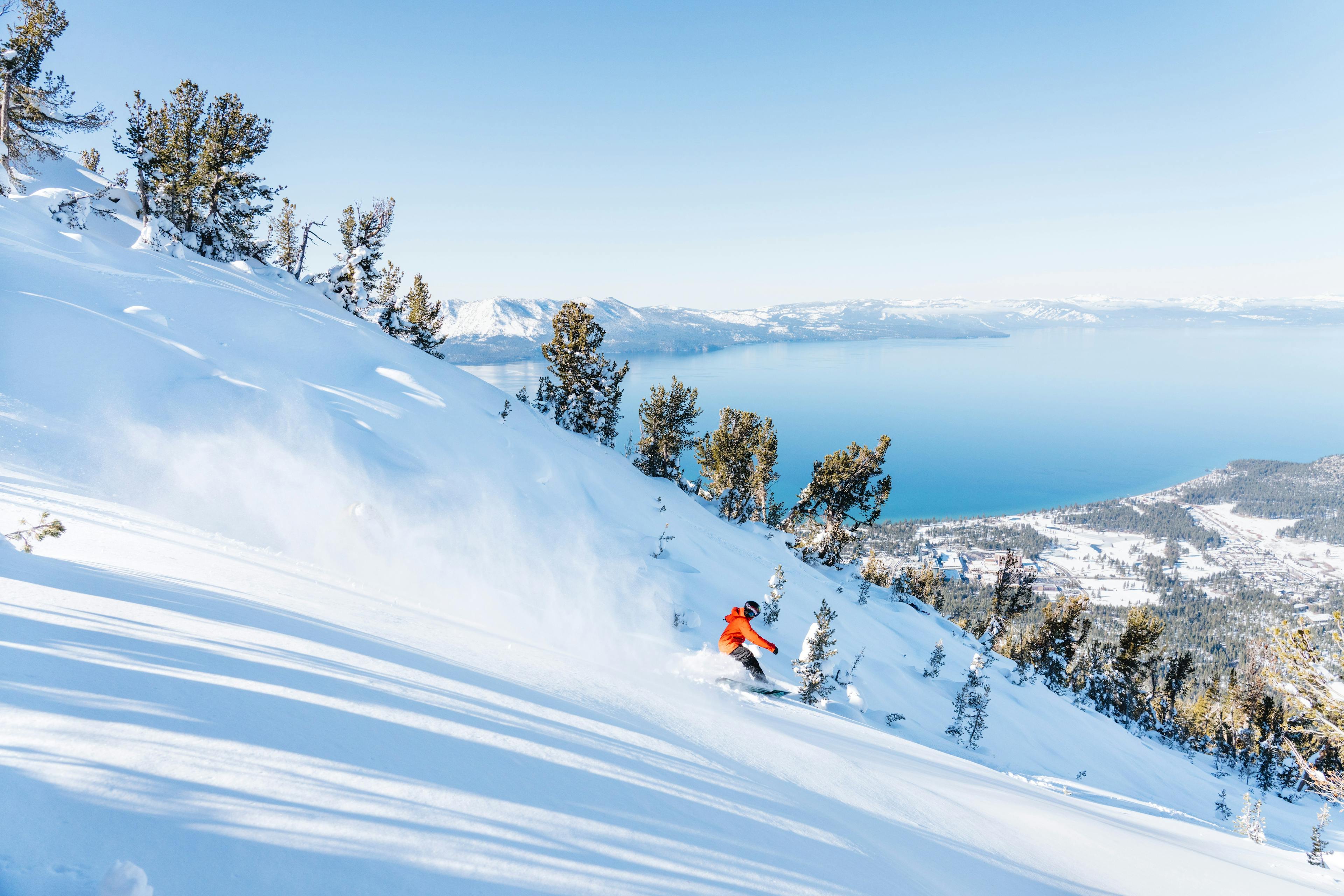 Skier skiing down the slopes of Heavenly Resort with Lake Tahoe in the backdrop