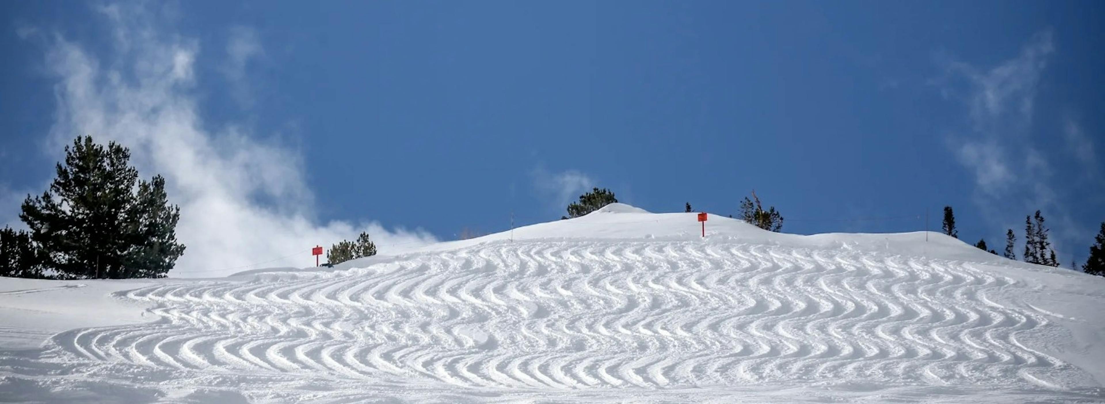Lines of squiggly ski tracks left behind by David Van Dame on a snowy powder slope at Alta Ski Resort