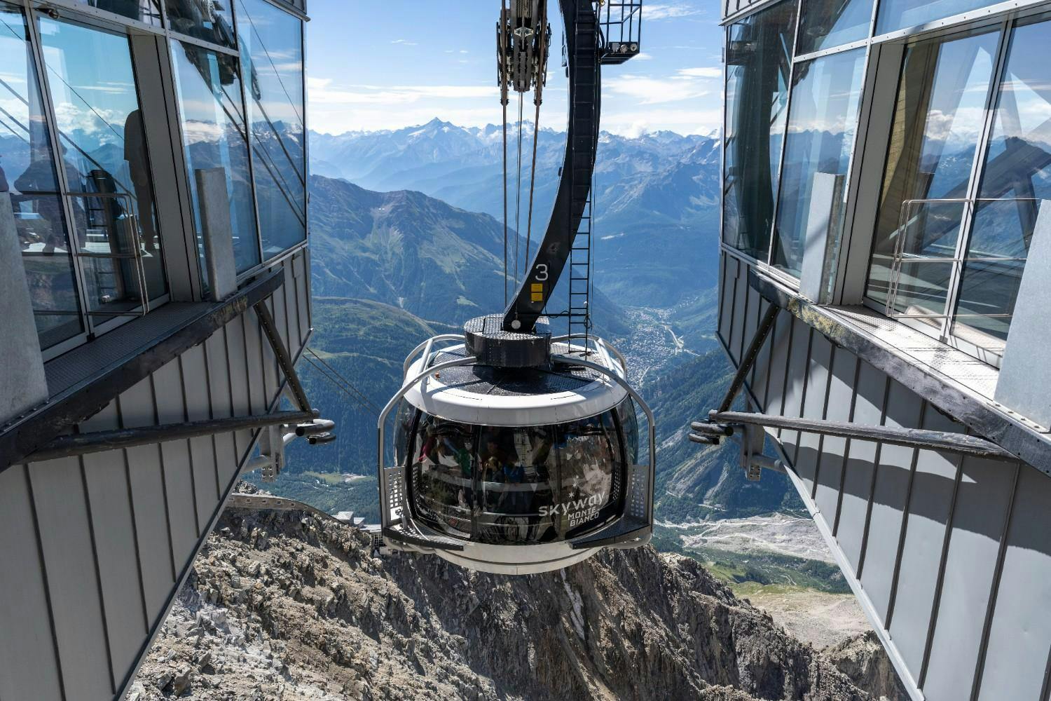 Aerial view of a rotating cable car on Skyway Monte Bianco hanging over Mont Blanc