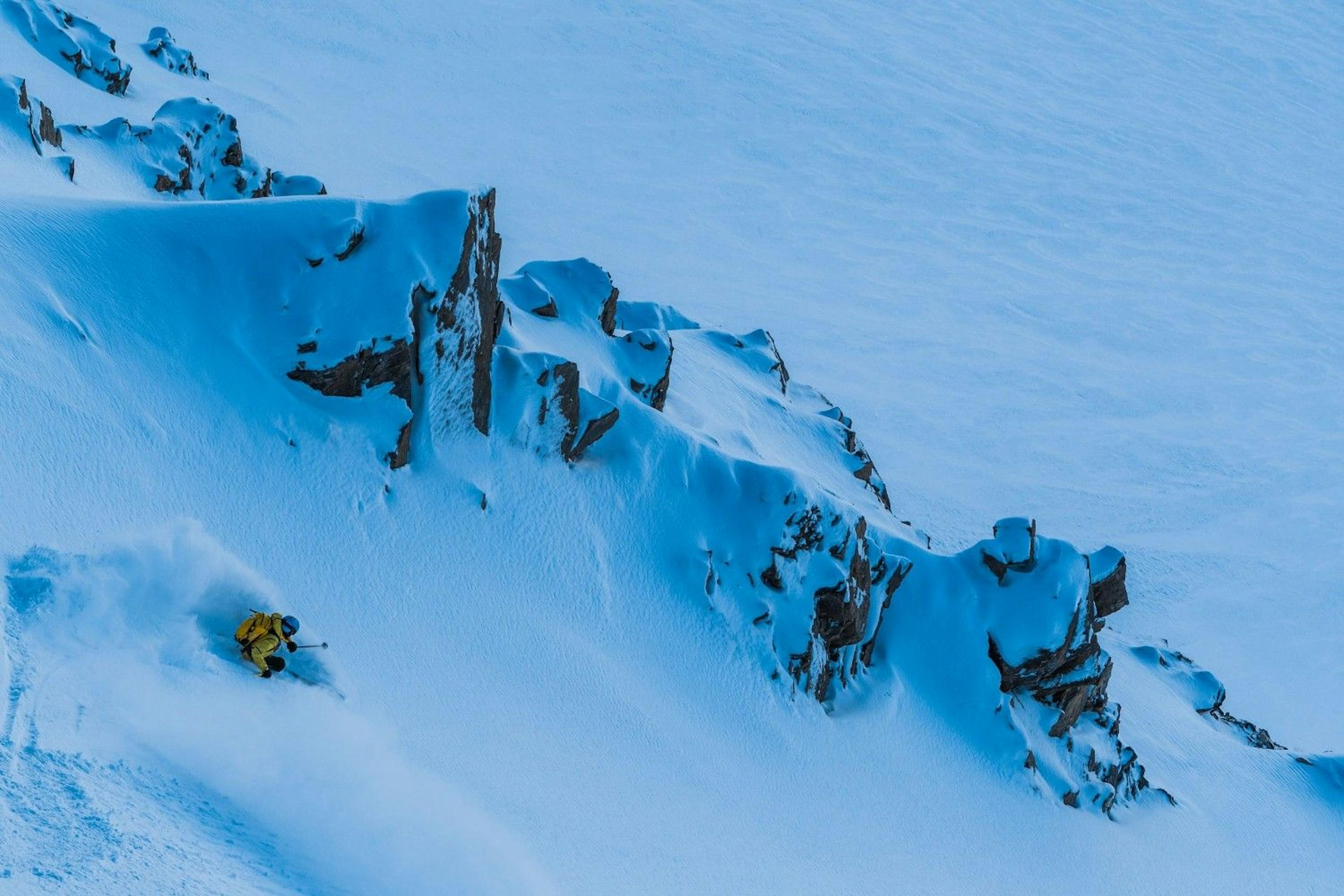 Freeride skier skiing down a steep powder cliff at Courmayeur Resort