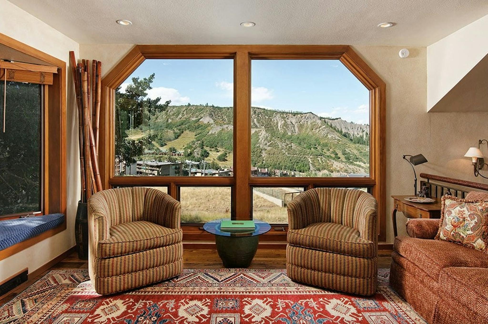 A huge window with a beautiful view of the Aspen Snowmass slopes framed by two armchairs in Residence 5 at Woodrun V Lodge