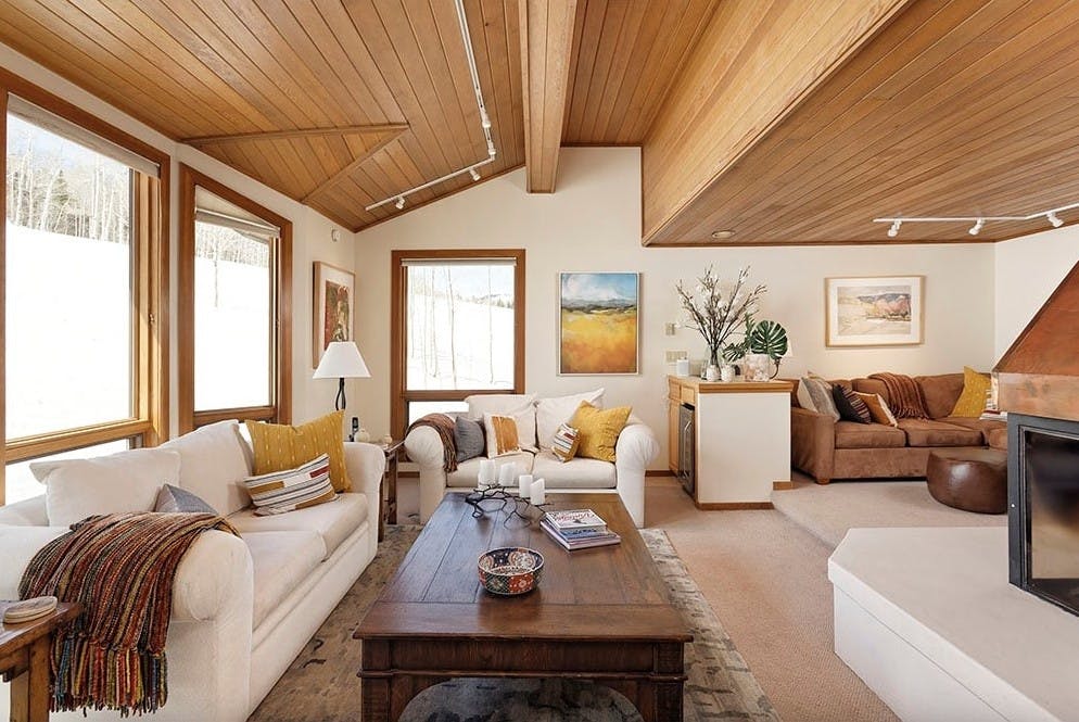 Modern, sleek cabin living room with snowy alpine views at Residence 17 at Woodrun V Snowmass
