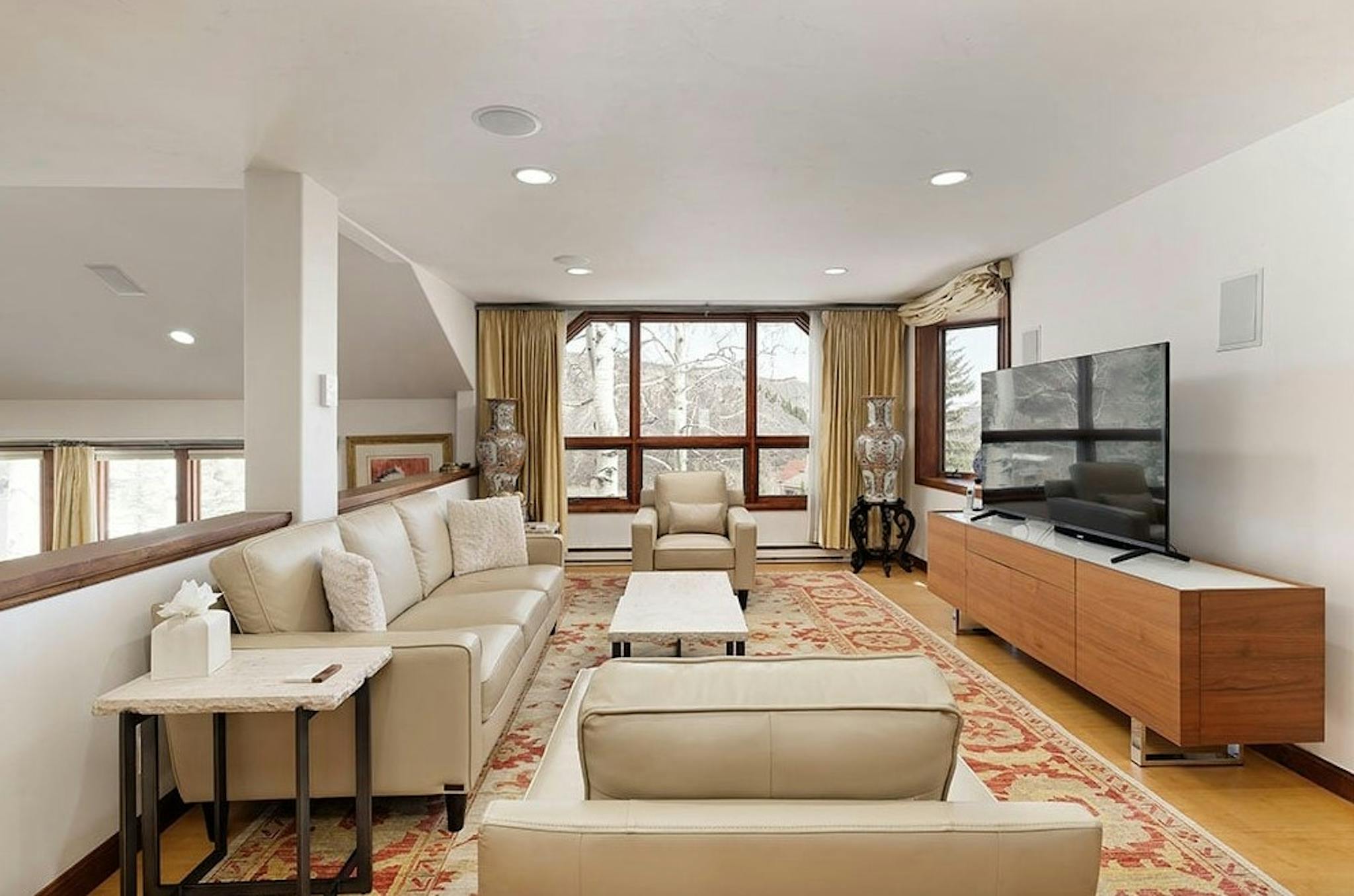 Modern TV room at Residence 13 at Woodrun Snowmass with sleep white couches and beautiful snowy alpine views