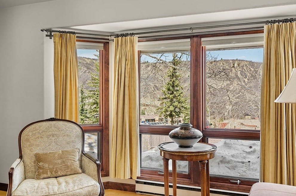 Antique chair sitting in front of big windows with gorgeous alpine views of Snowmass