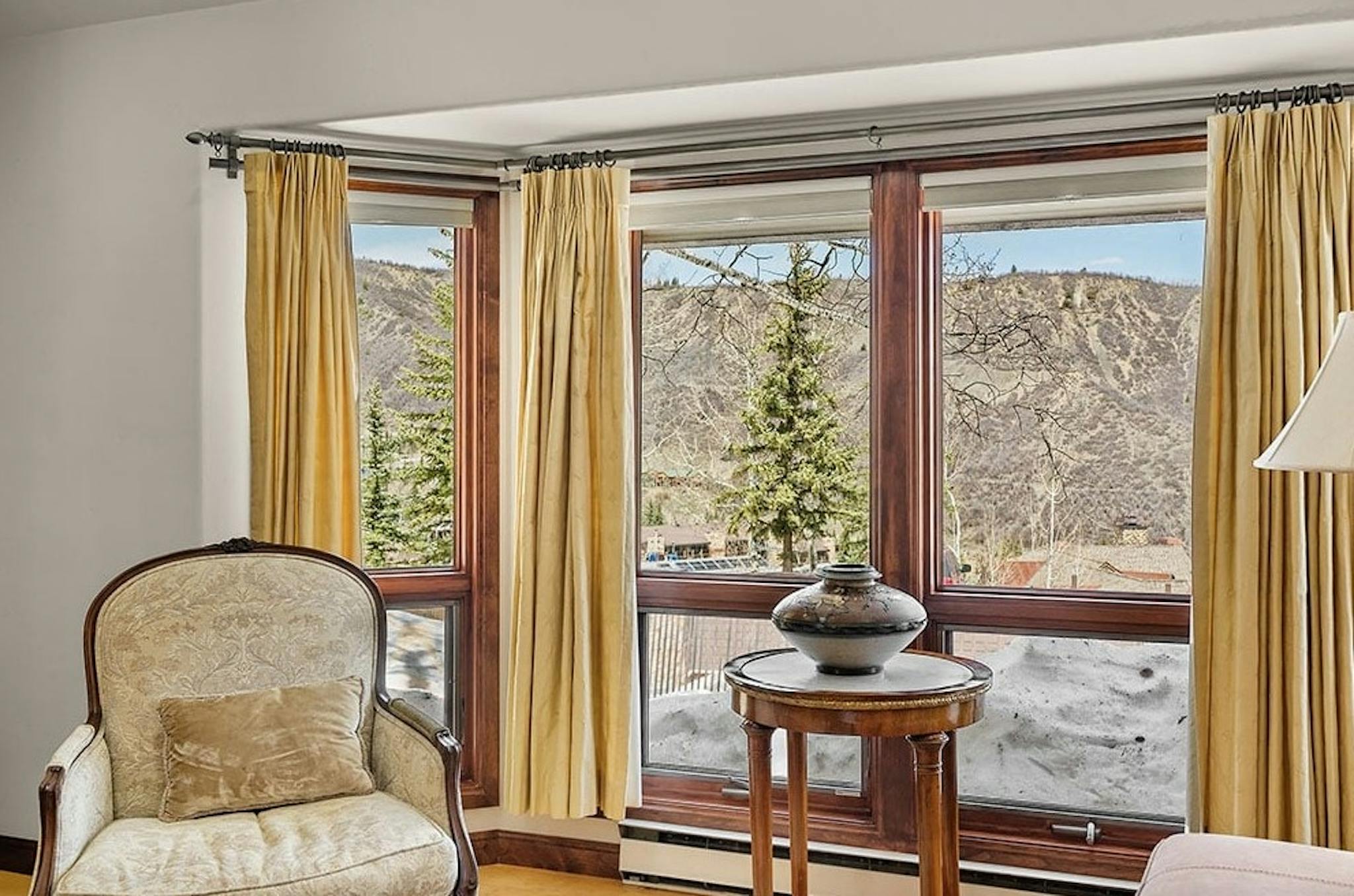 Antique chair sitting in front of big windows with gorgeous alpine views of Snowmass