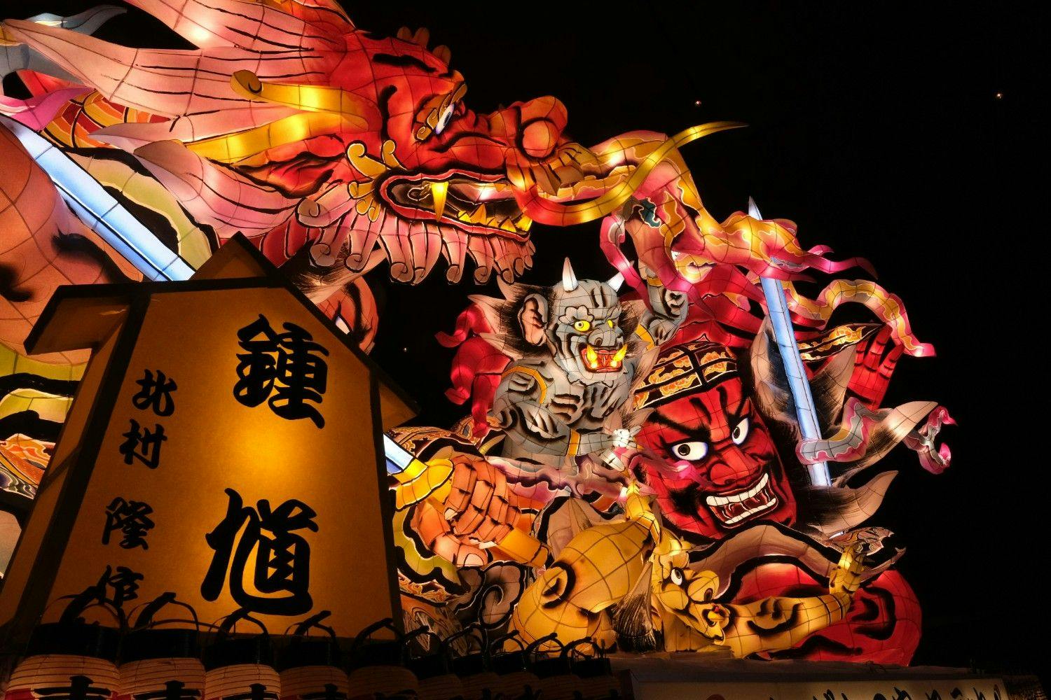 Light up inflatable dragons and flaming heads in a Japanese night festival