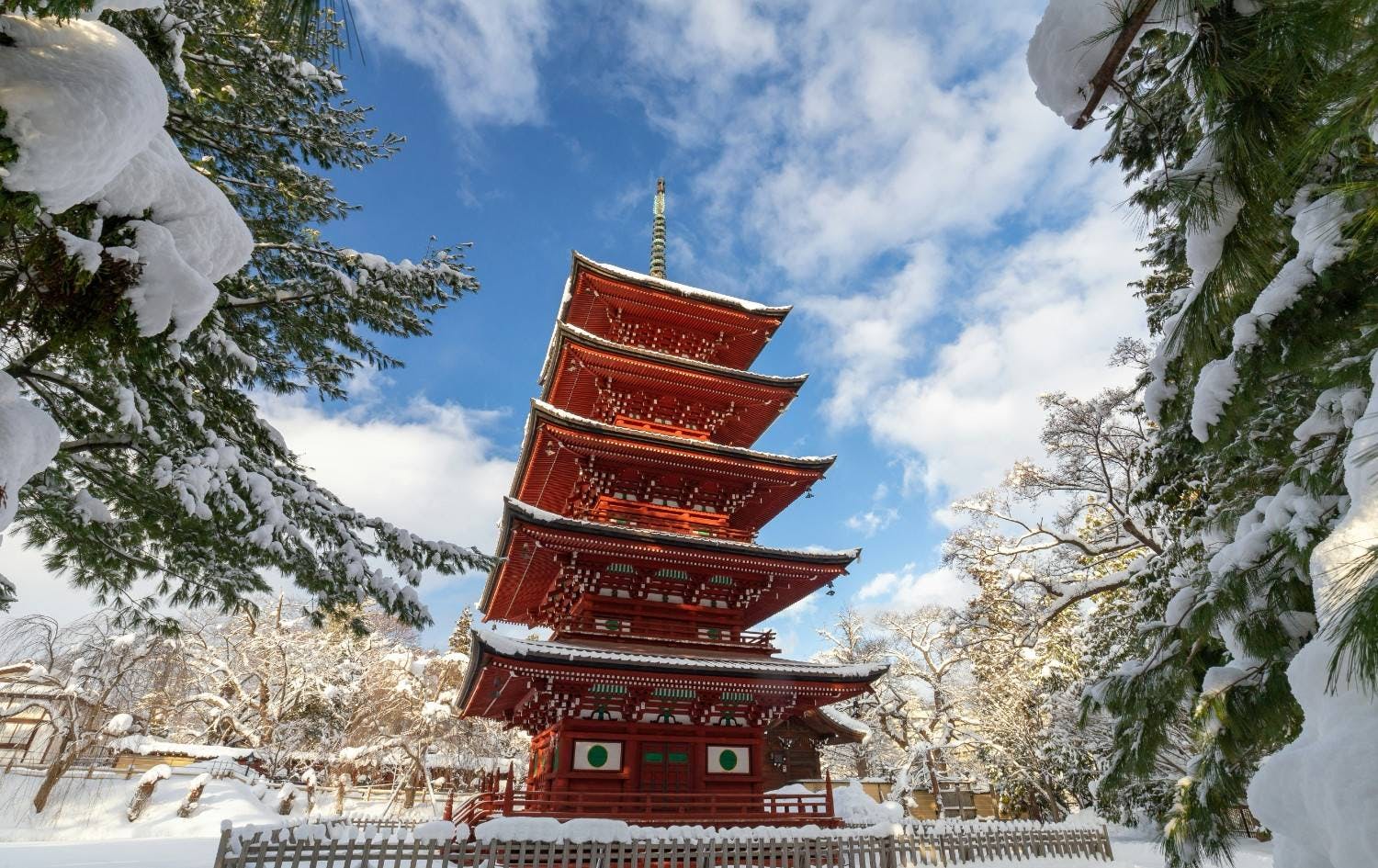 Snow-covered Japanese building framed by snowy trees