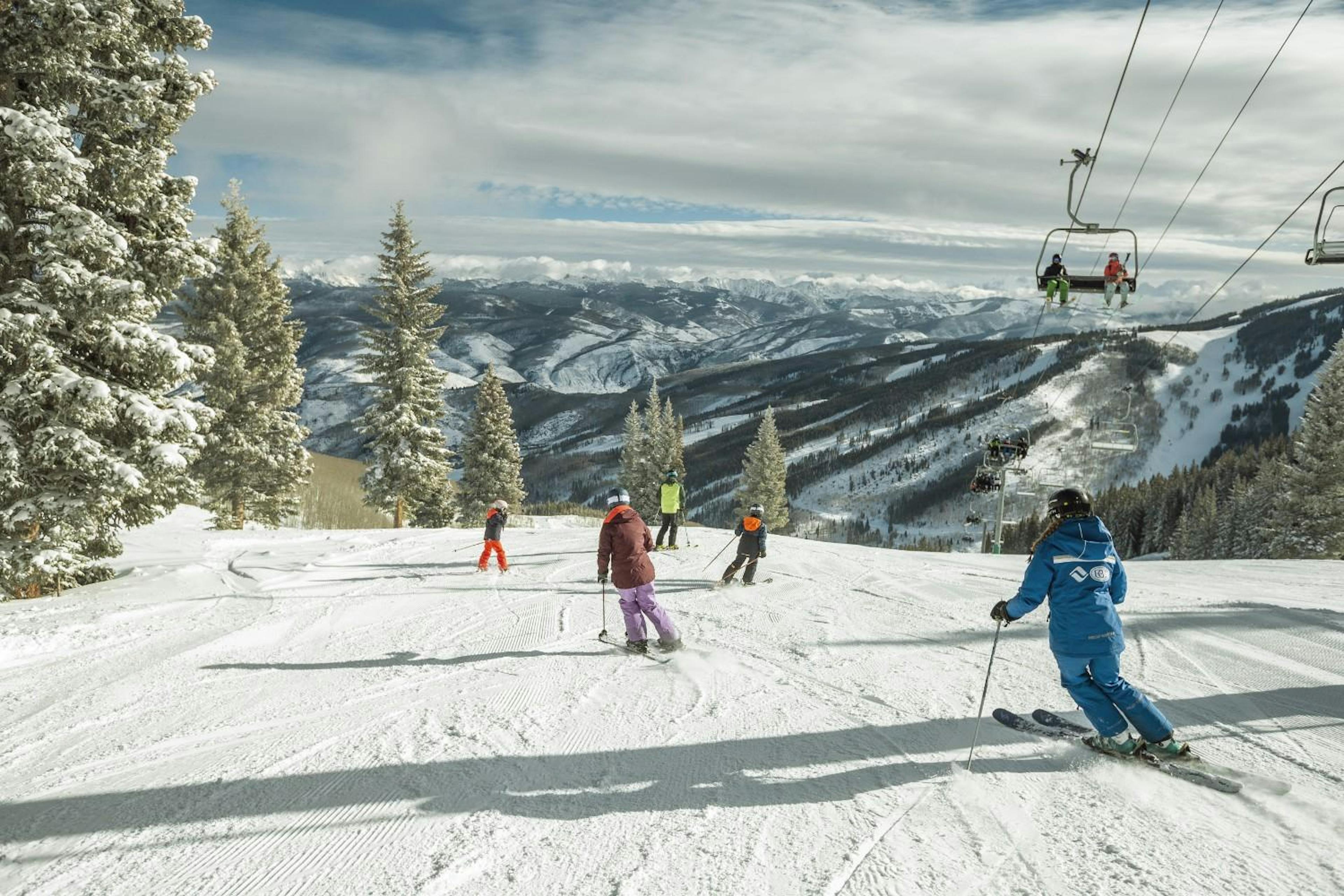 Beaver Creek ski instructor skiing behind a family of four on the slopes under the ski lift at Beaver Creek Resort