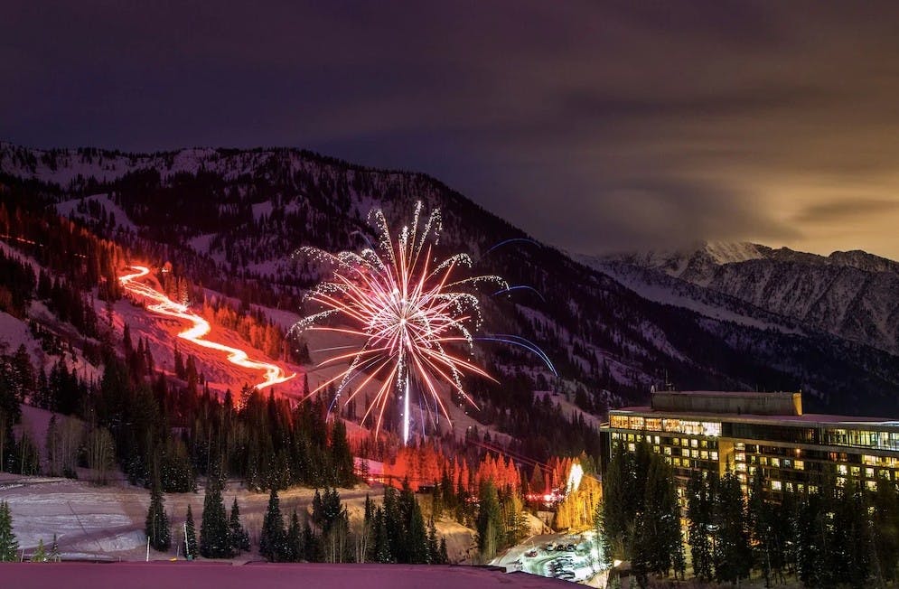 Aerial view of The Cliff Lodge Snowbird at dusk with fireworks over the slopes of Snowbird Resort