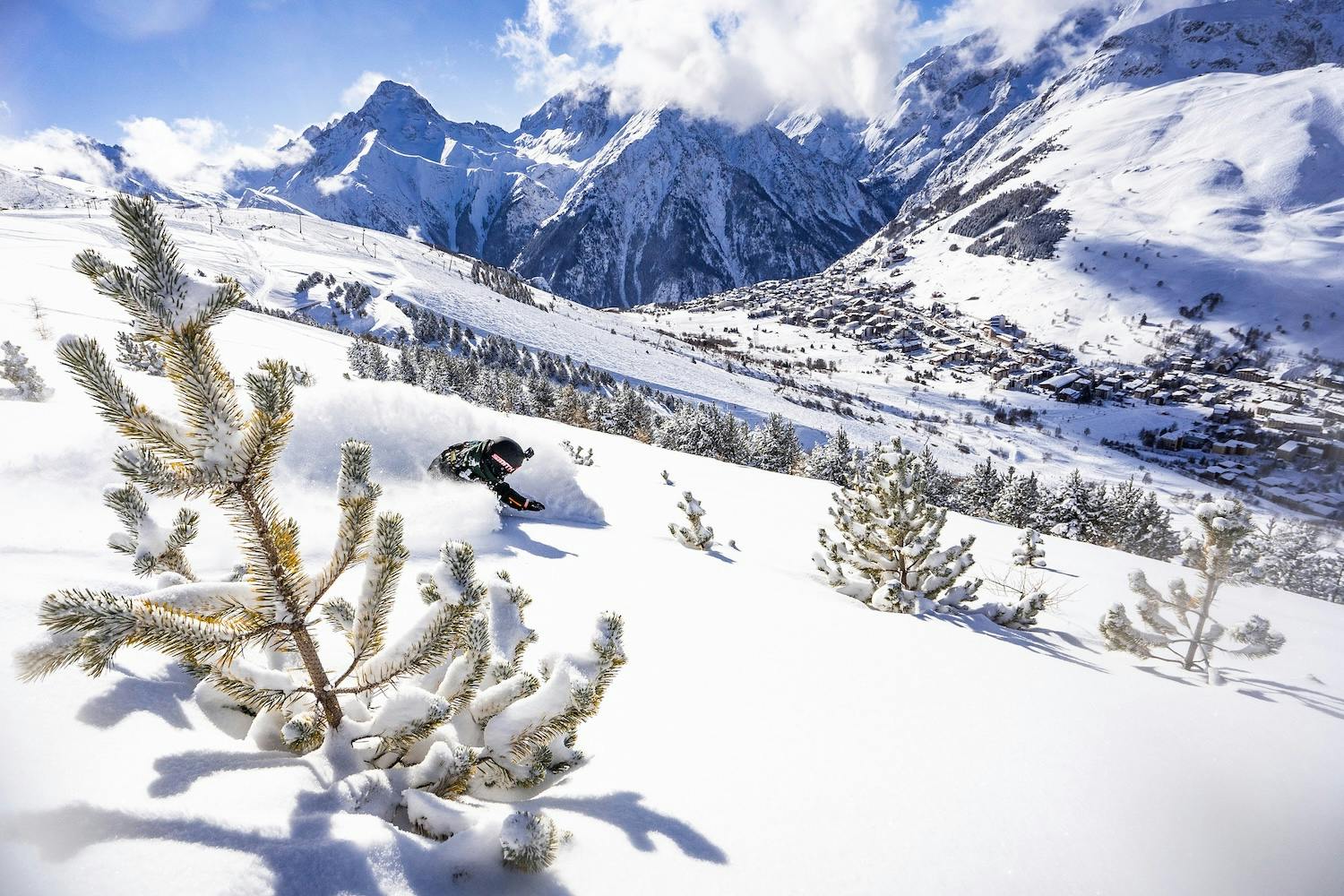 A skier carving through fresh snow on a mountain slope, surrounded by a winter landscape.