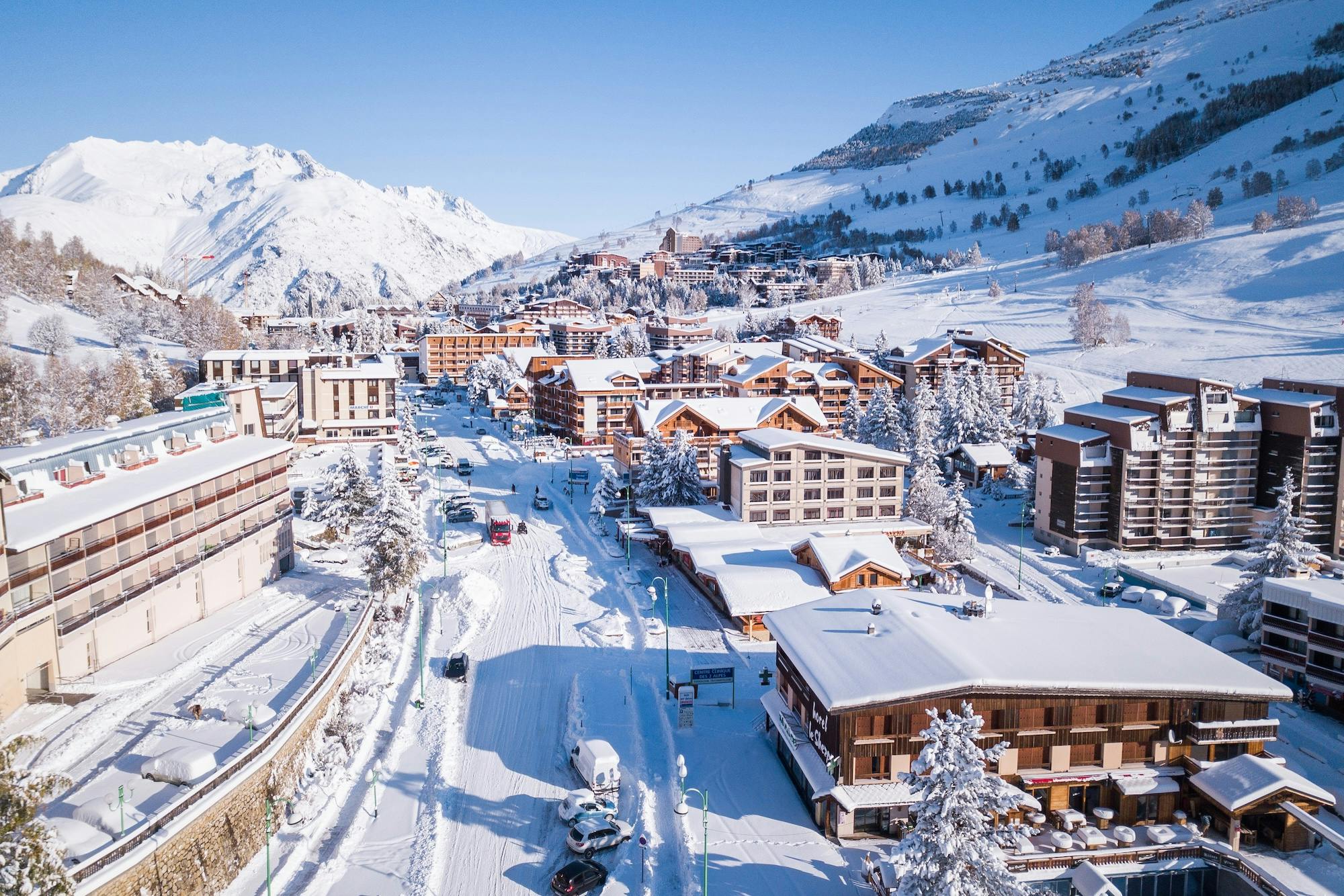 picturesque mountain village blanketed in snow, showcasing charming houses and serene winter scenery.