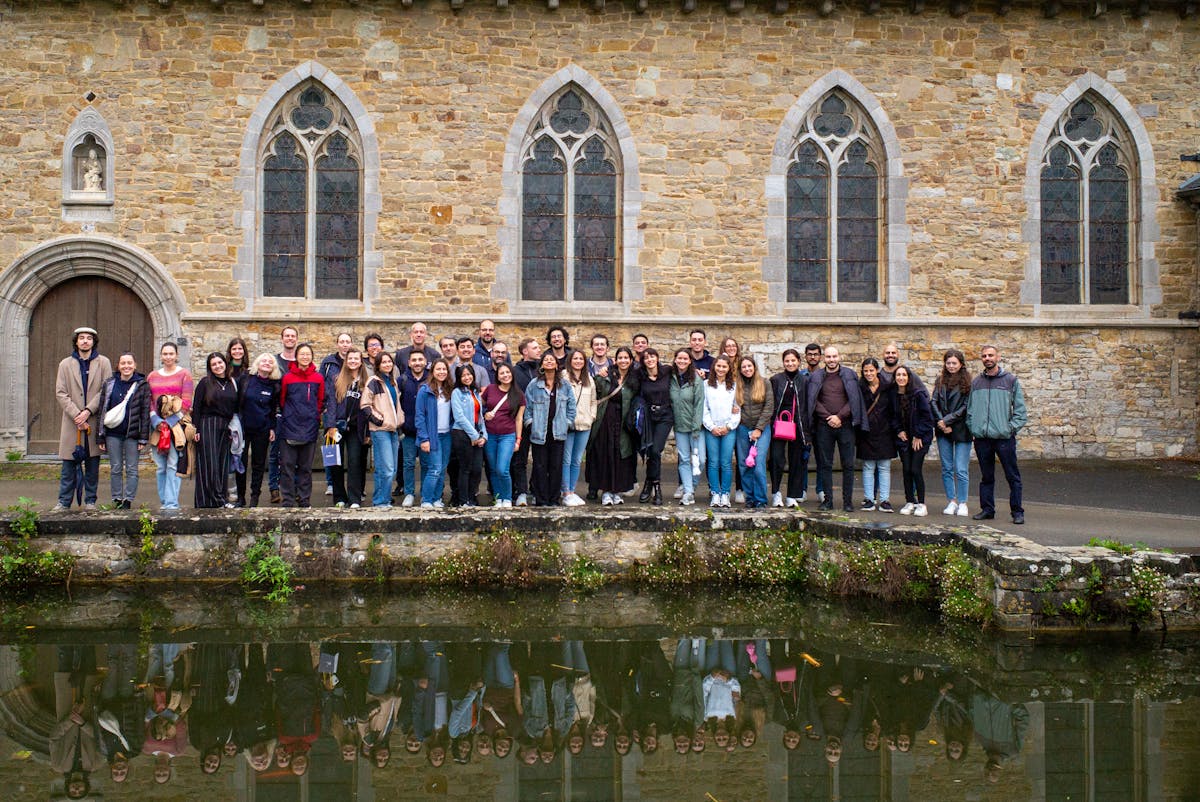 SkillLab team standing together and taking a photo in front of old abbey in Dinant