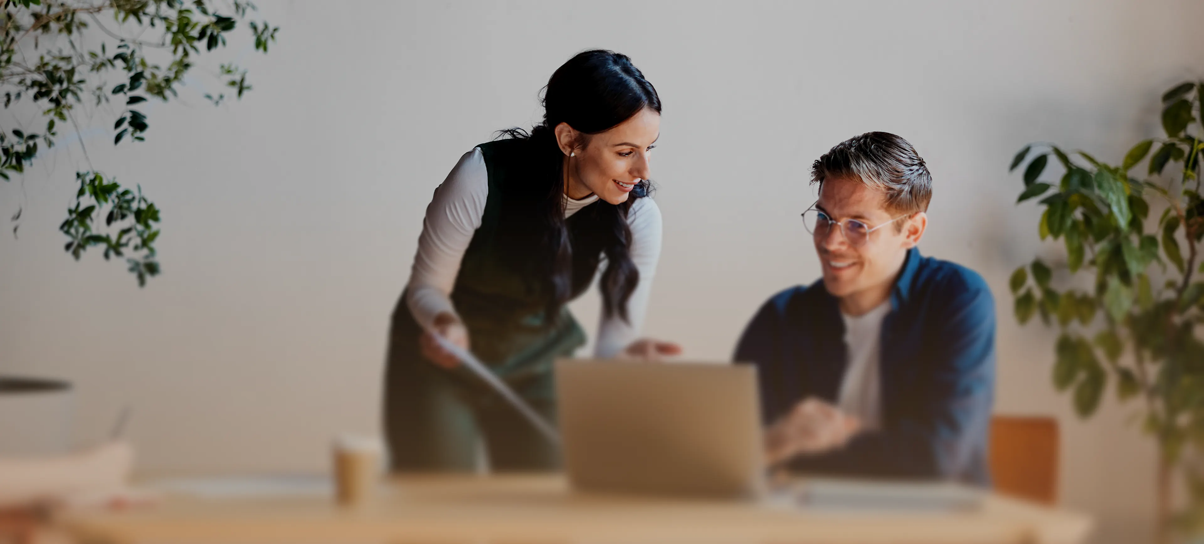 Deux collaborateurs échangent devant un ordinateur portable