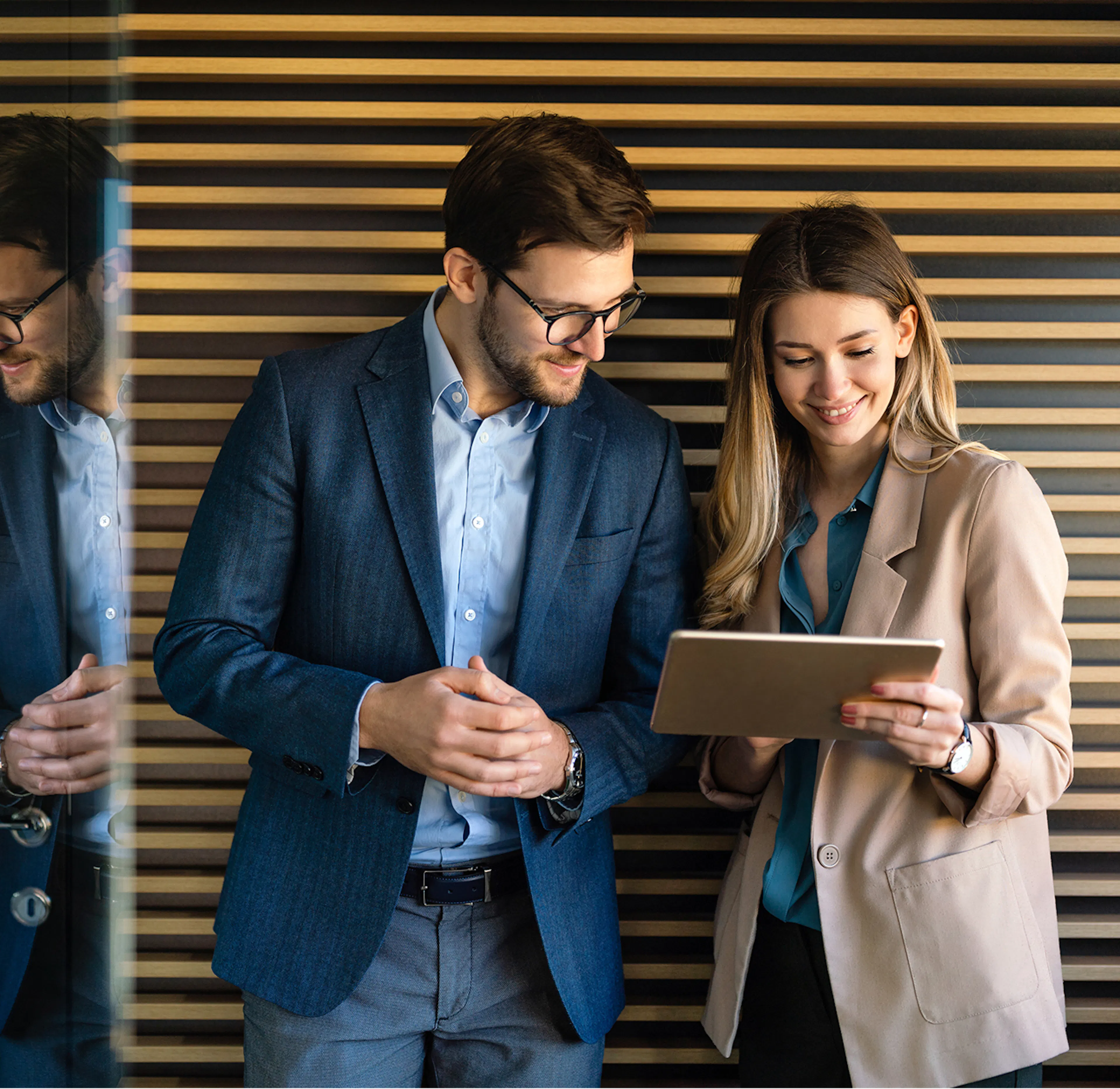 Deux collaborateurs échangent devant une tablette