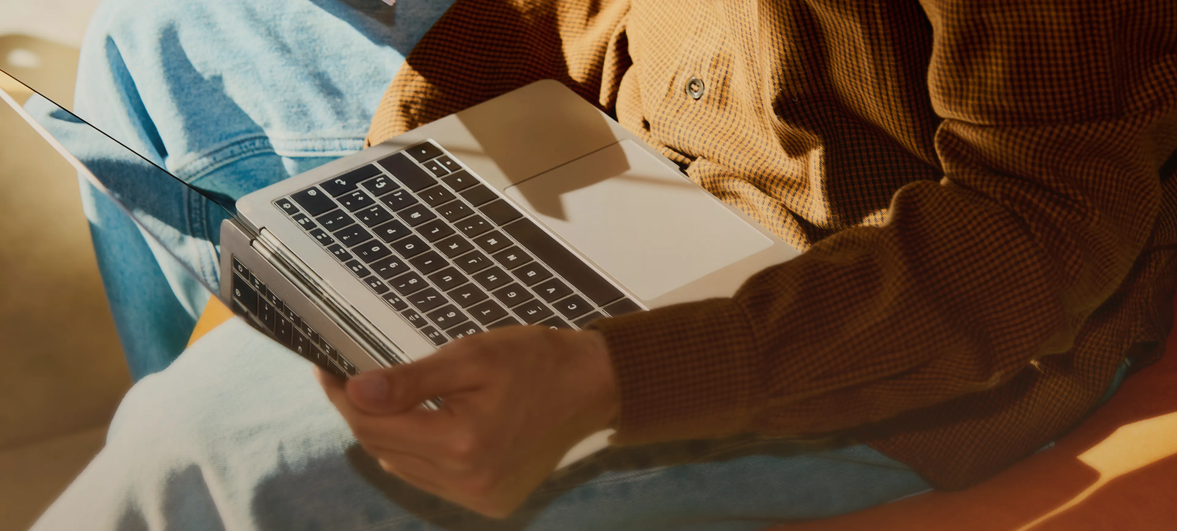Collaborateur qui travaille sur un ordinateur portable posé sur ses genoux