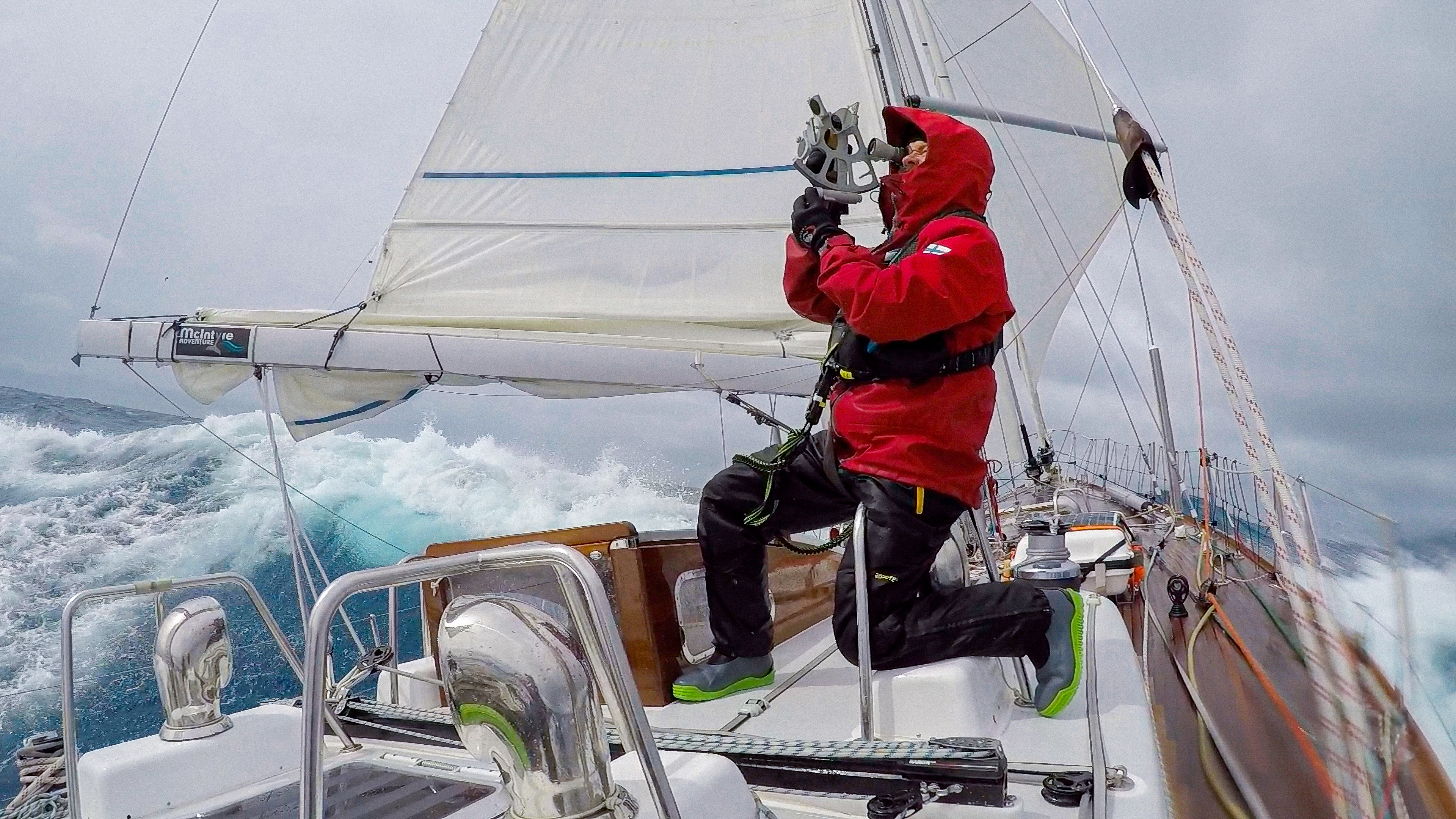 A man using a sextant on the deck of a sailing boat