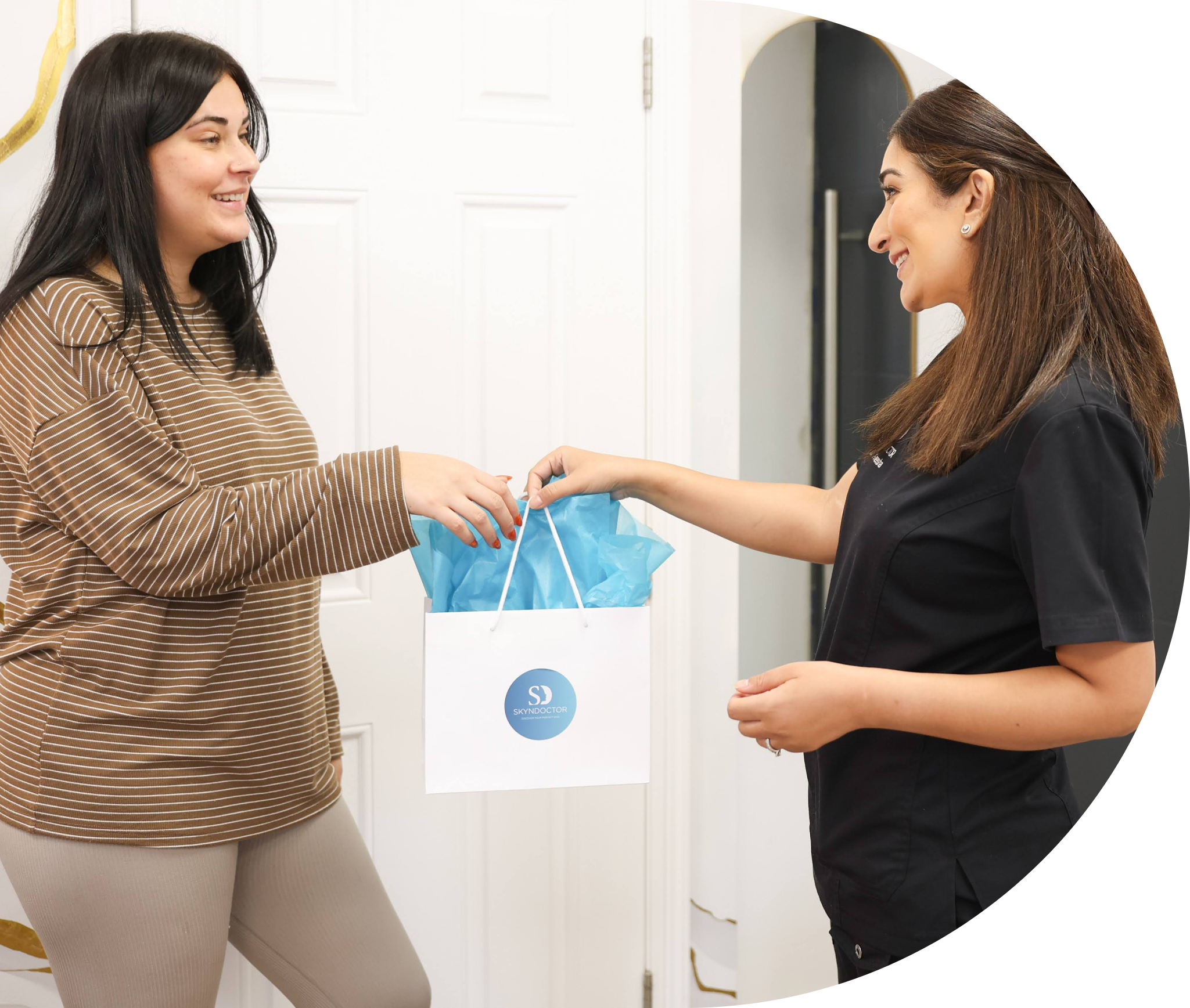 Dr Aneesha handing a treatment gift to a patient