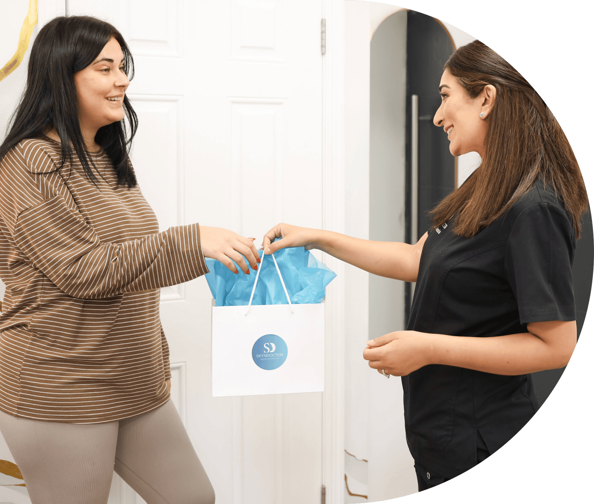 Dr Aneesha handing a treatment gift to a patient