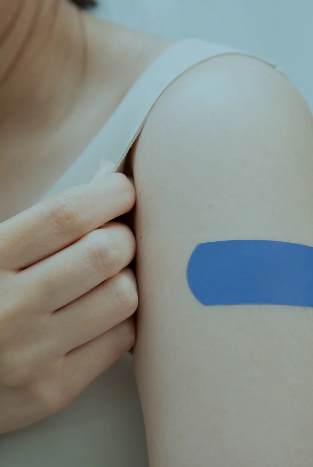young woman with a plaster on her arm after a vaccination