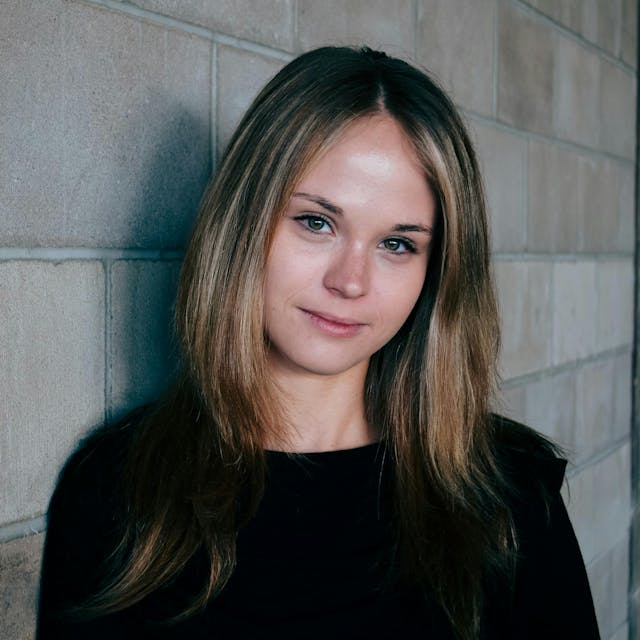 women next to a brick wall