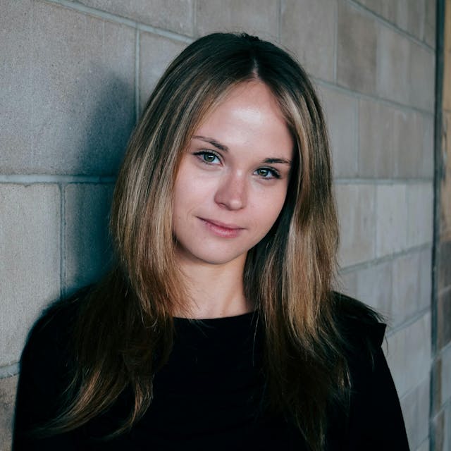 women next to a brick wall