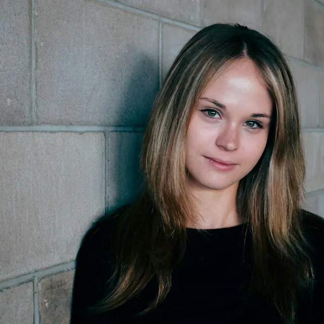 women next to a brick wall