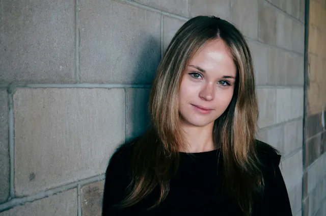 women next to a brick wall