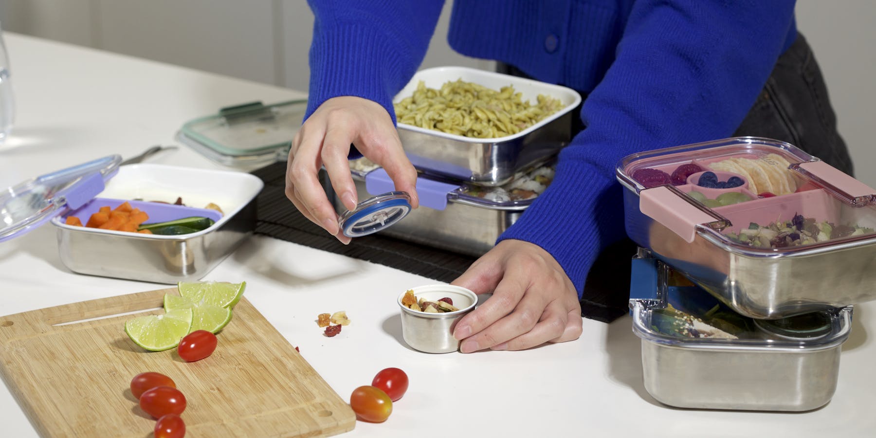 A person preparing meal for stainless steel bento boxes