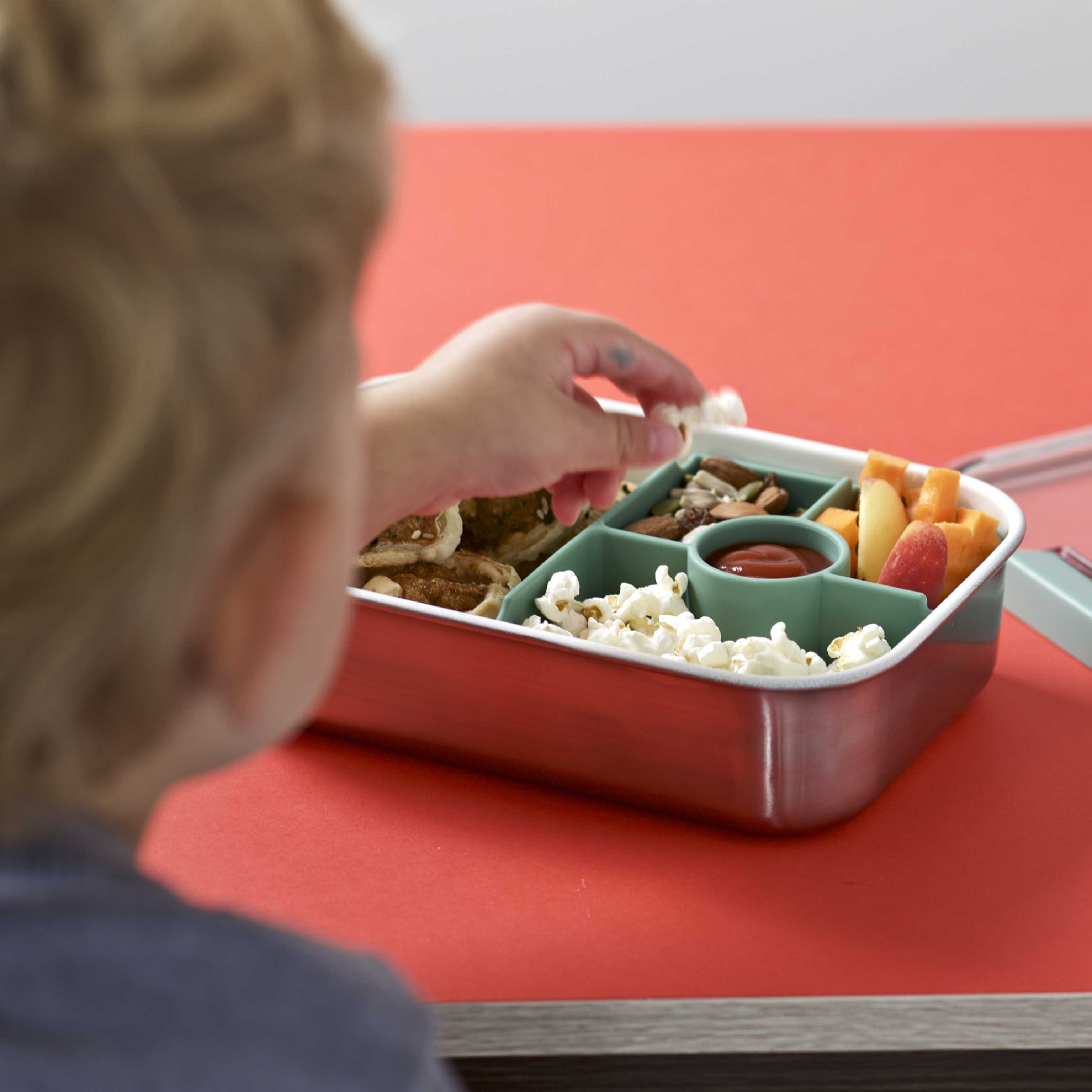 Kid grabbing popcorn from the lunch box