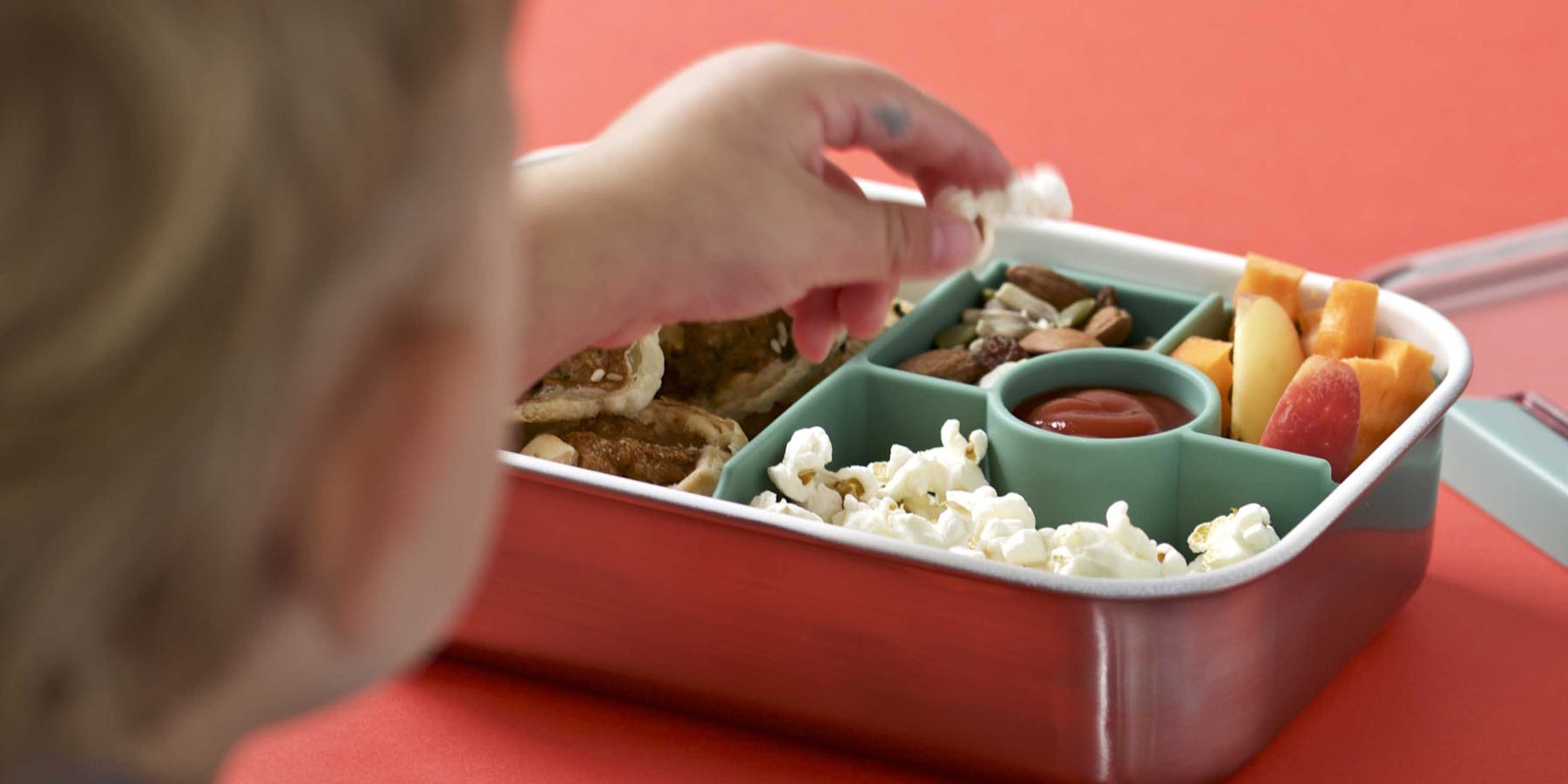Kid grabbing popcorn from the lunch box