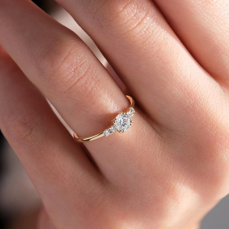 A minimalist dainty engagement ring with a tiny round brilliant cut