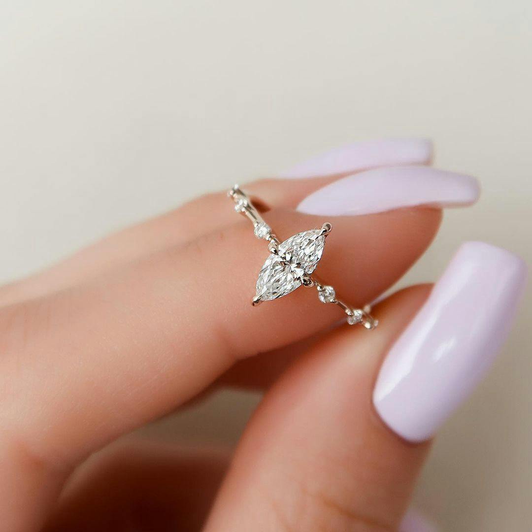 A minimalist unique engagement ring with a marquise-cut moissanite