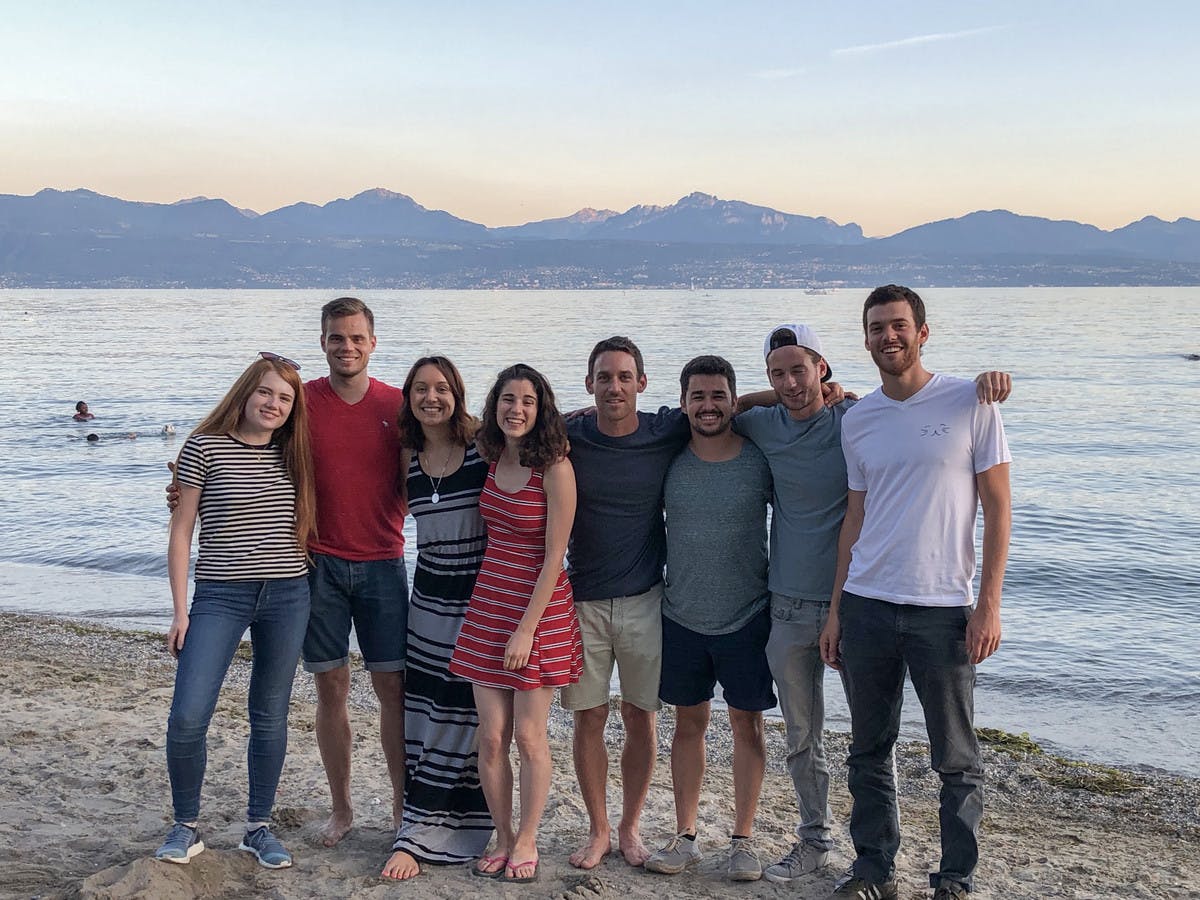 Smeetz team members hugging and smiling wearing on the beach in Lausanne.
