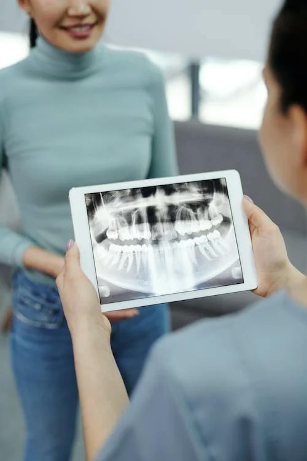 Doctor reviewing a dental X-ray digital image on a tab pic
