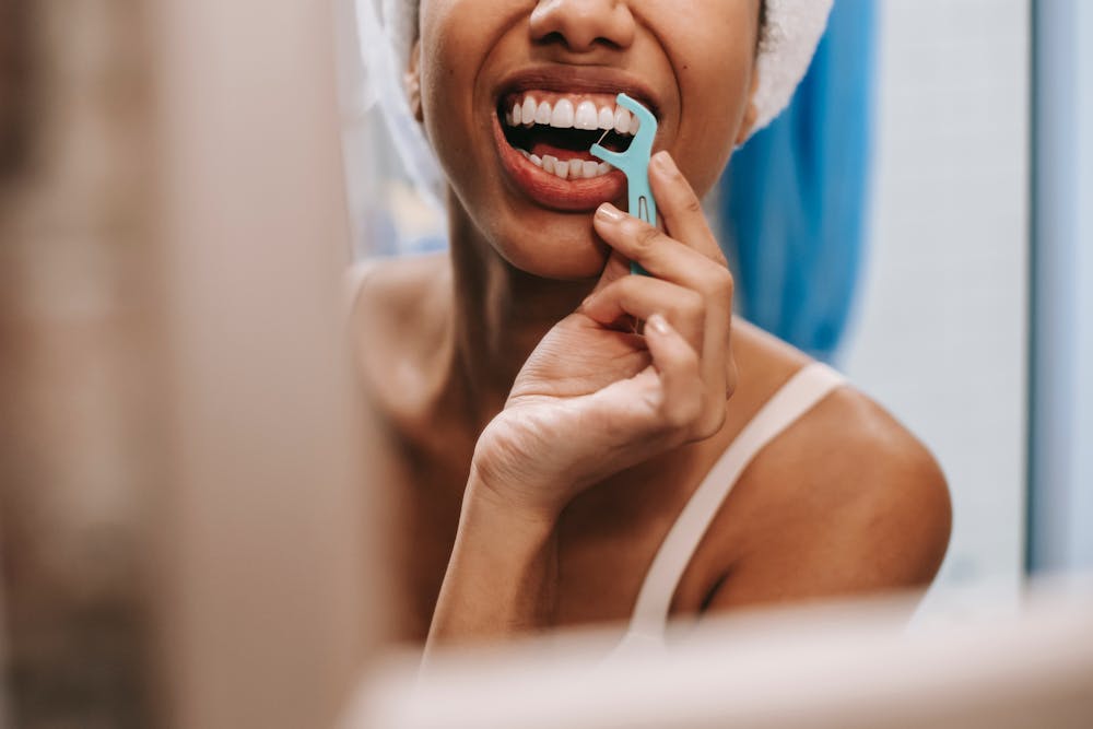 Photo of a woman flossing her teeth