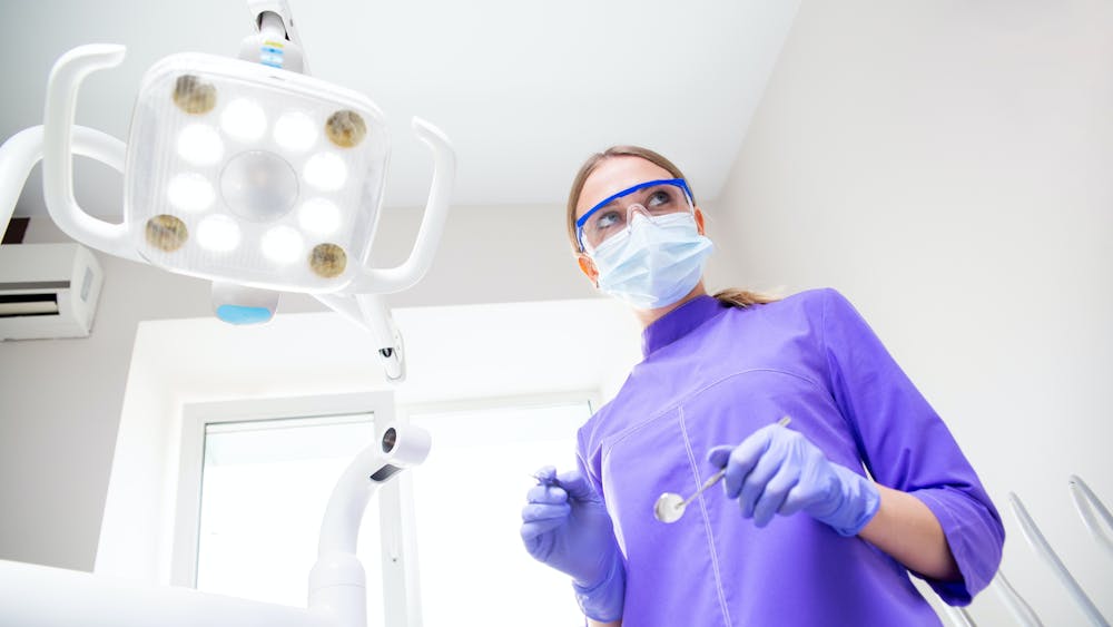 A dentist preparing for teeth whitening procedure