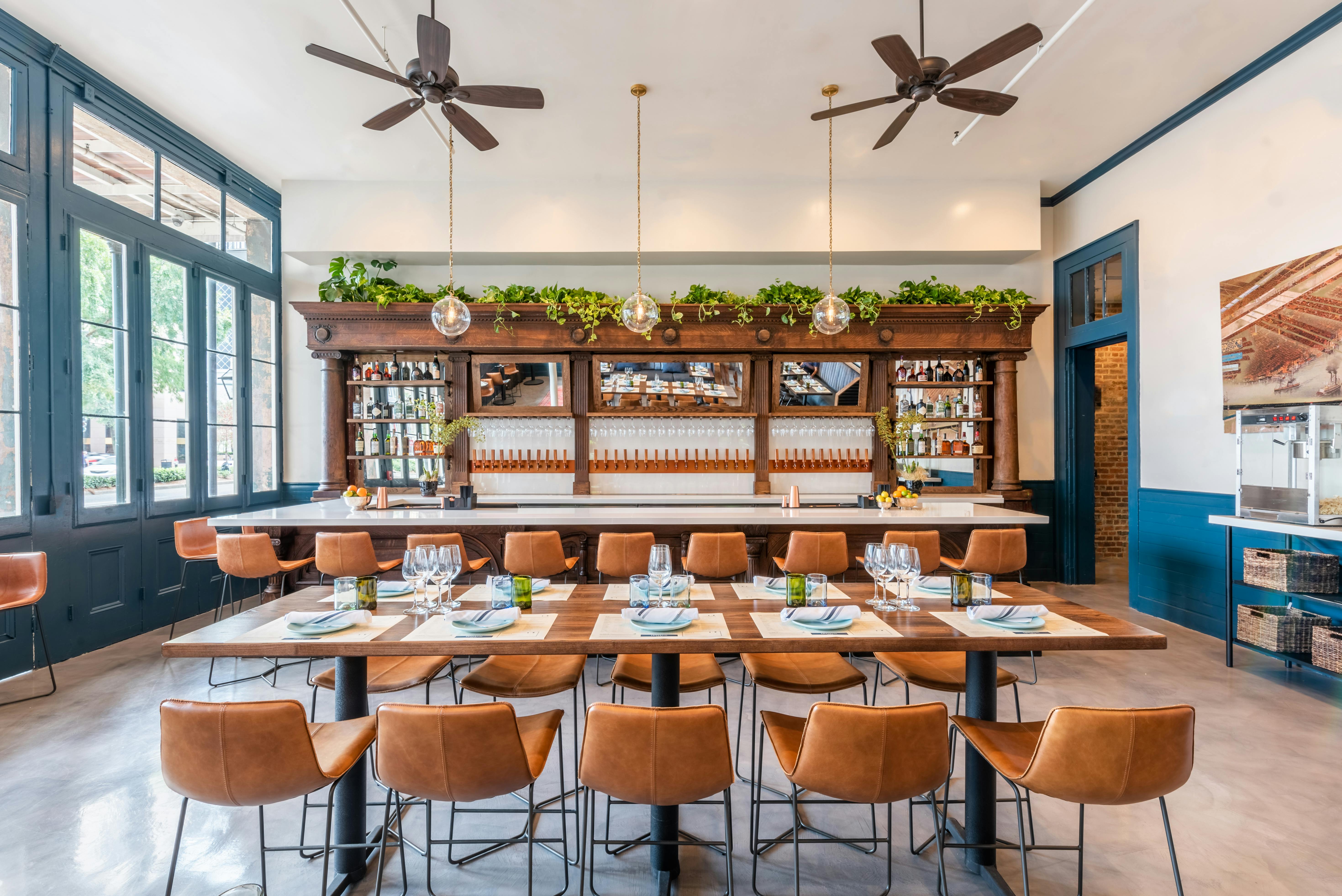 Interior view of Coppervine restaurant, wall of wine on tap, leather seating, wood furnishings, and navy blue accents.