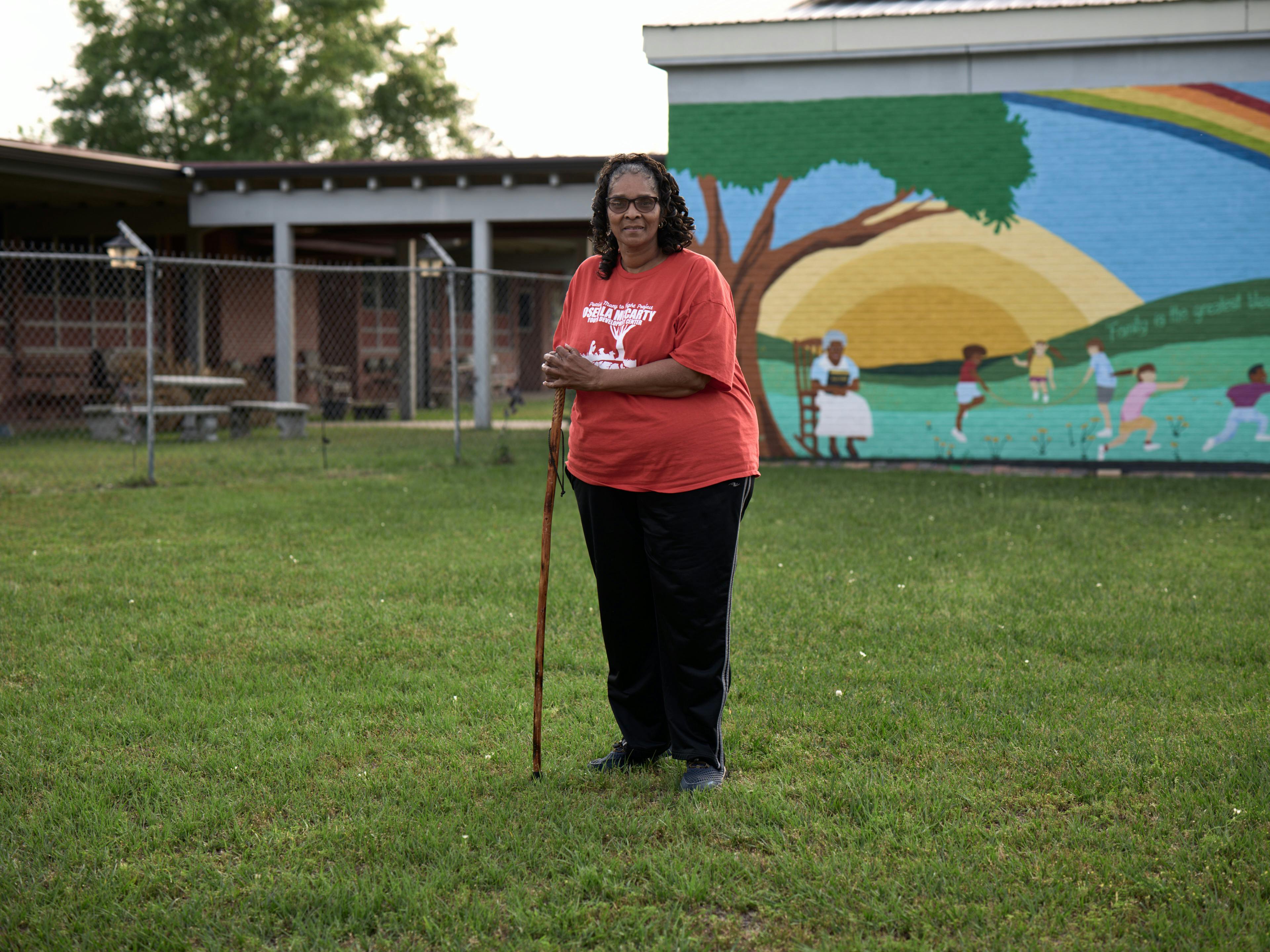 woman standing in yard in front of mural