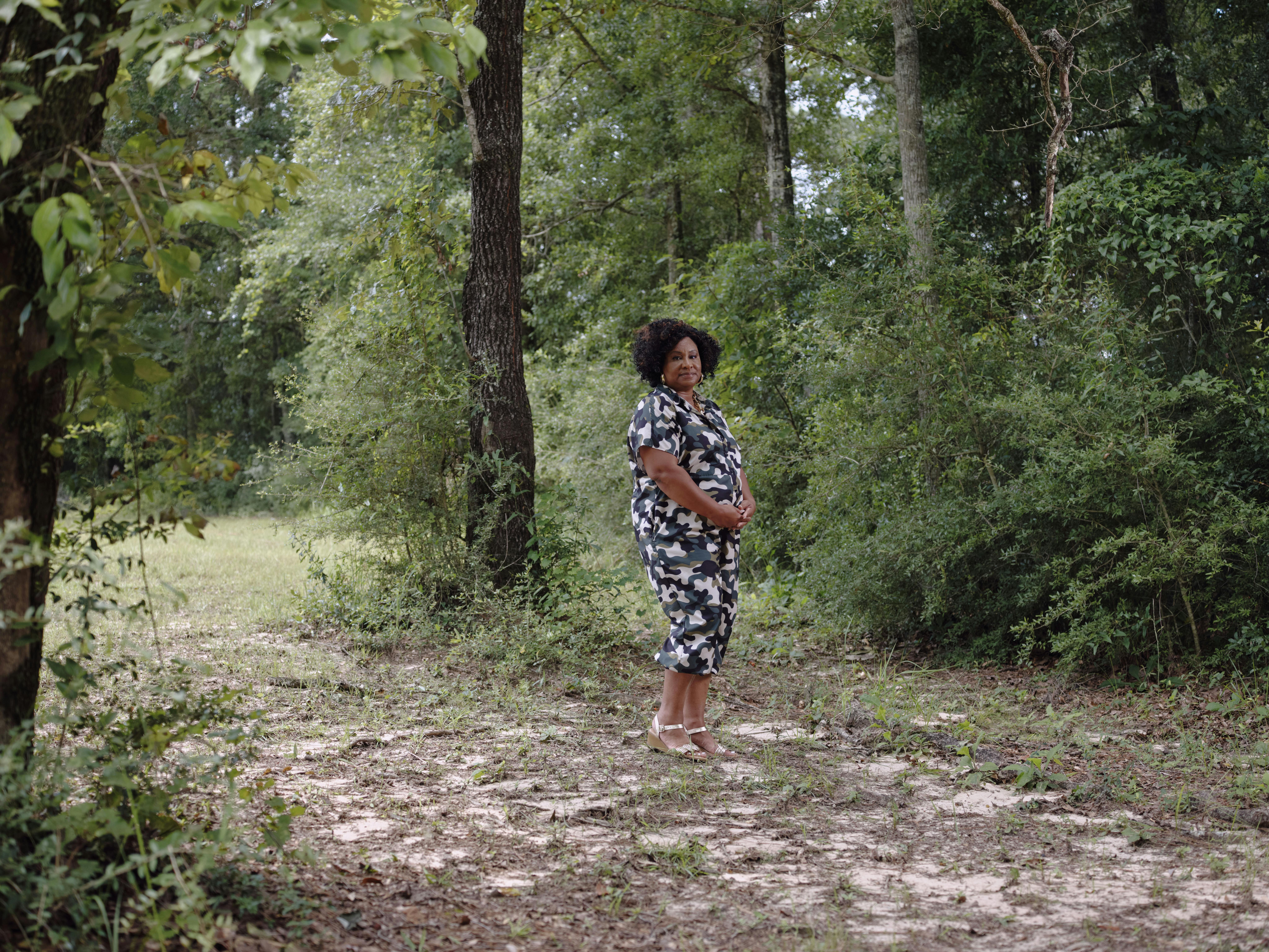 woman standing in shaded forest clearing