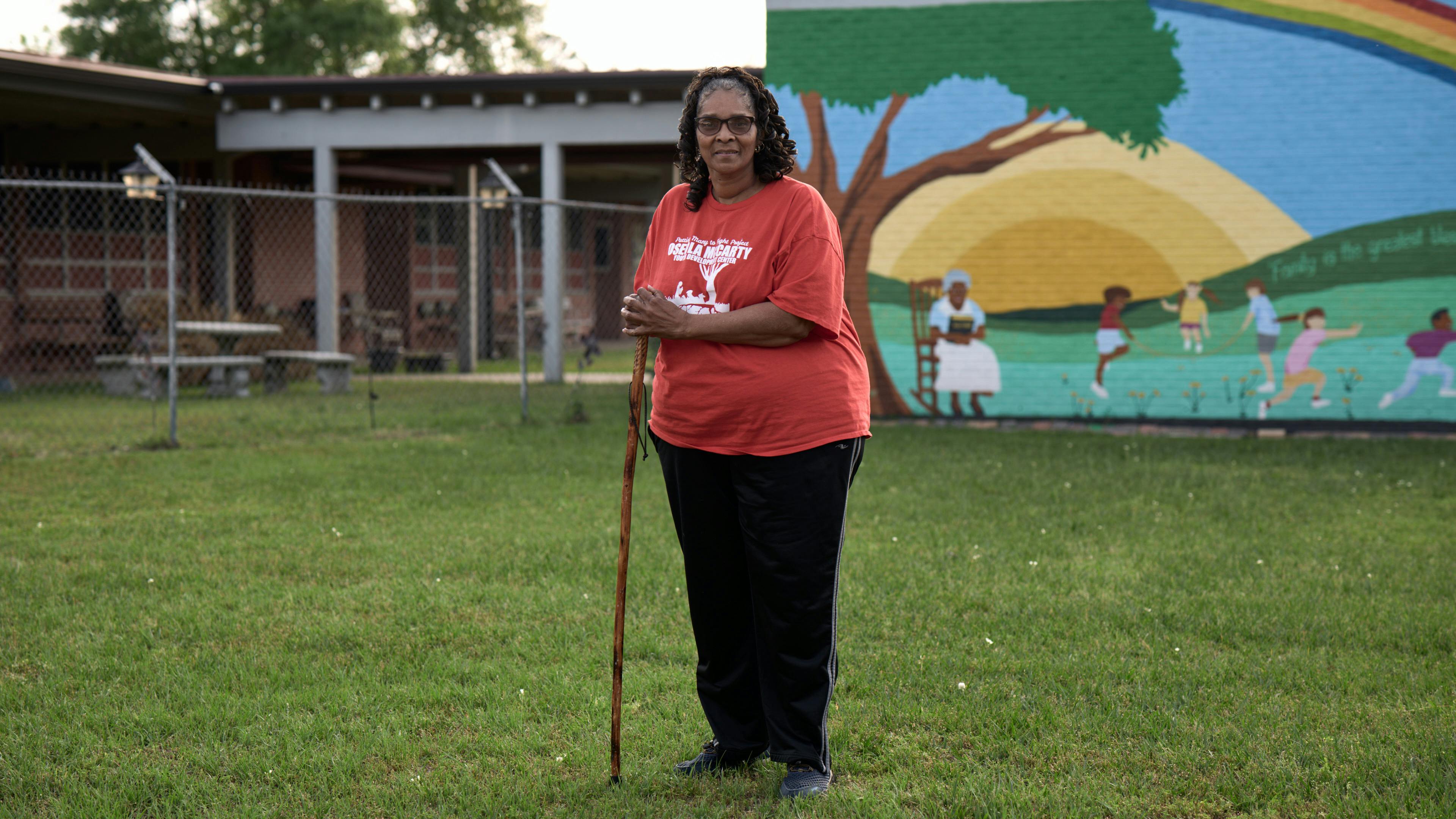 woman standing in yard in front of mural