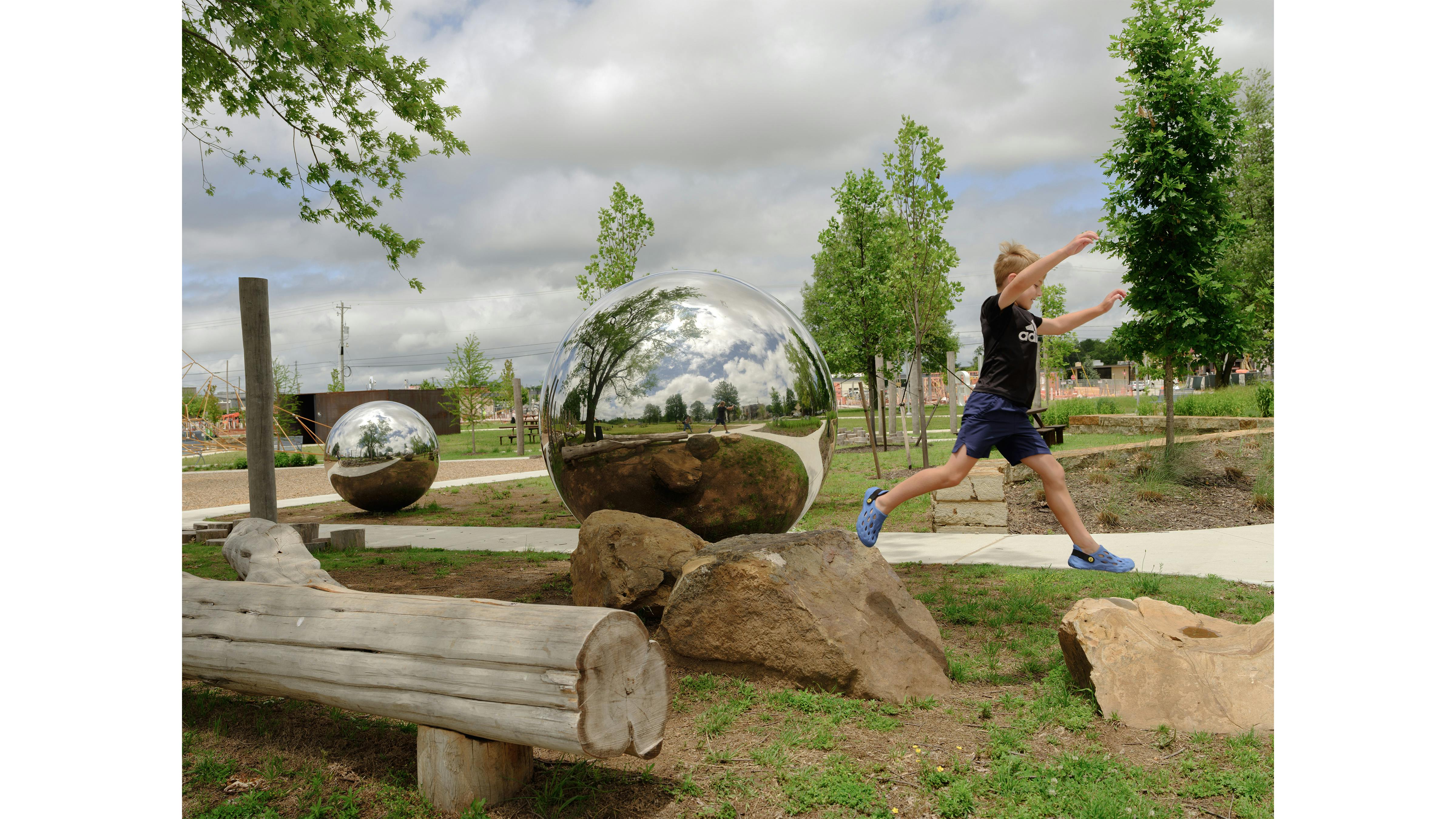 child jumping across two big rocks