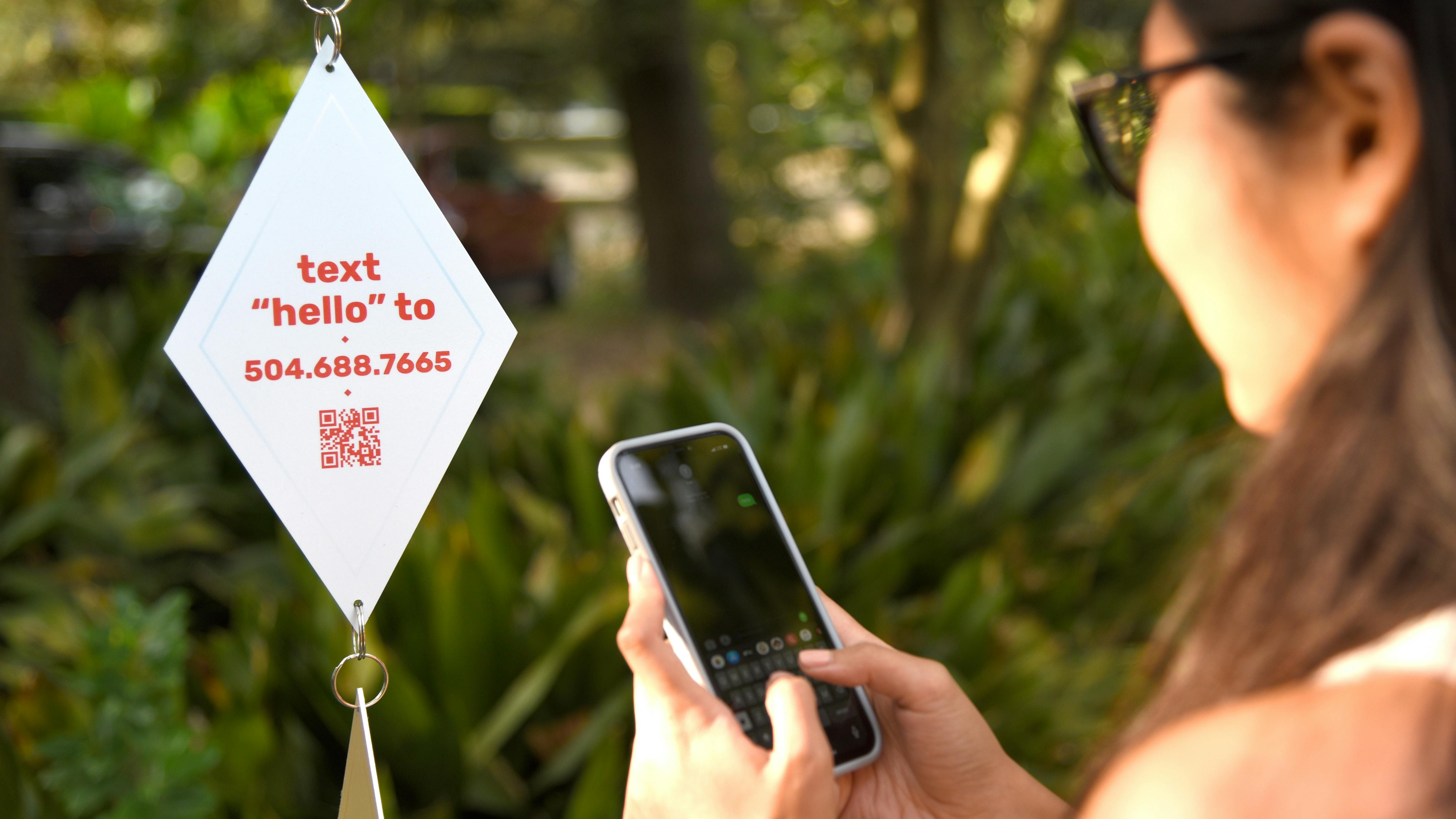 Diamond shape Talk Tree To Me prototype with QR code and optional phone number hanging from tree.