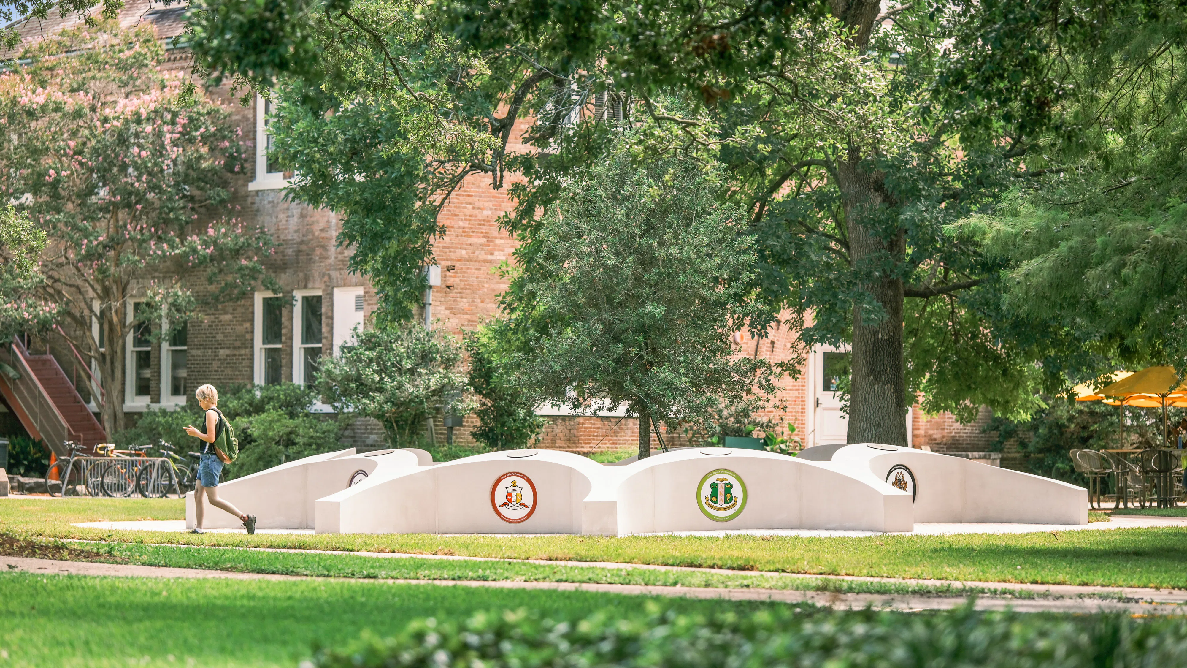 A person walks by the NPHC monument on Tulane's campus