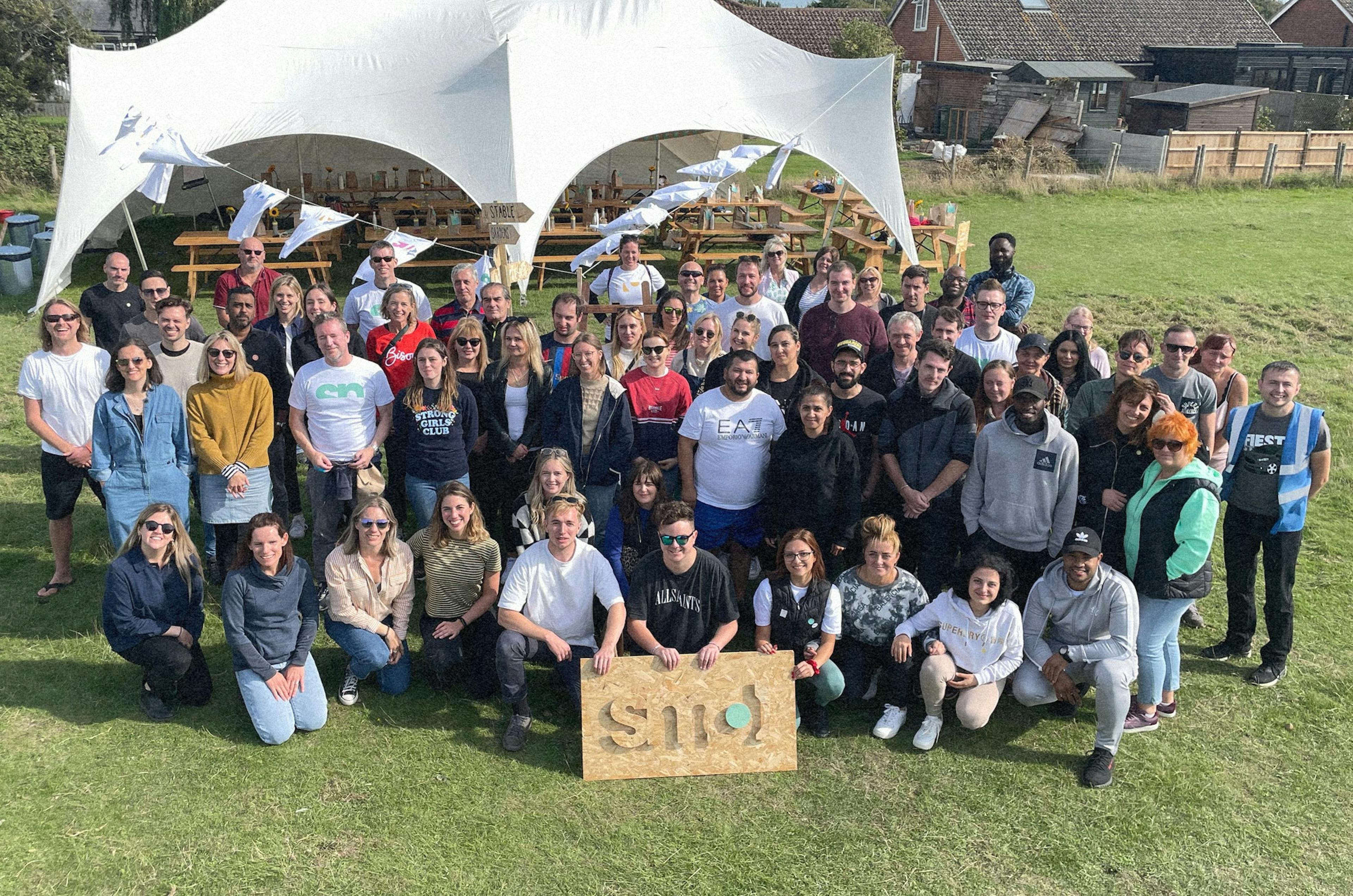 ein Gruppenfoto des smol Teams im Freien auf einer grünen Wiese