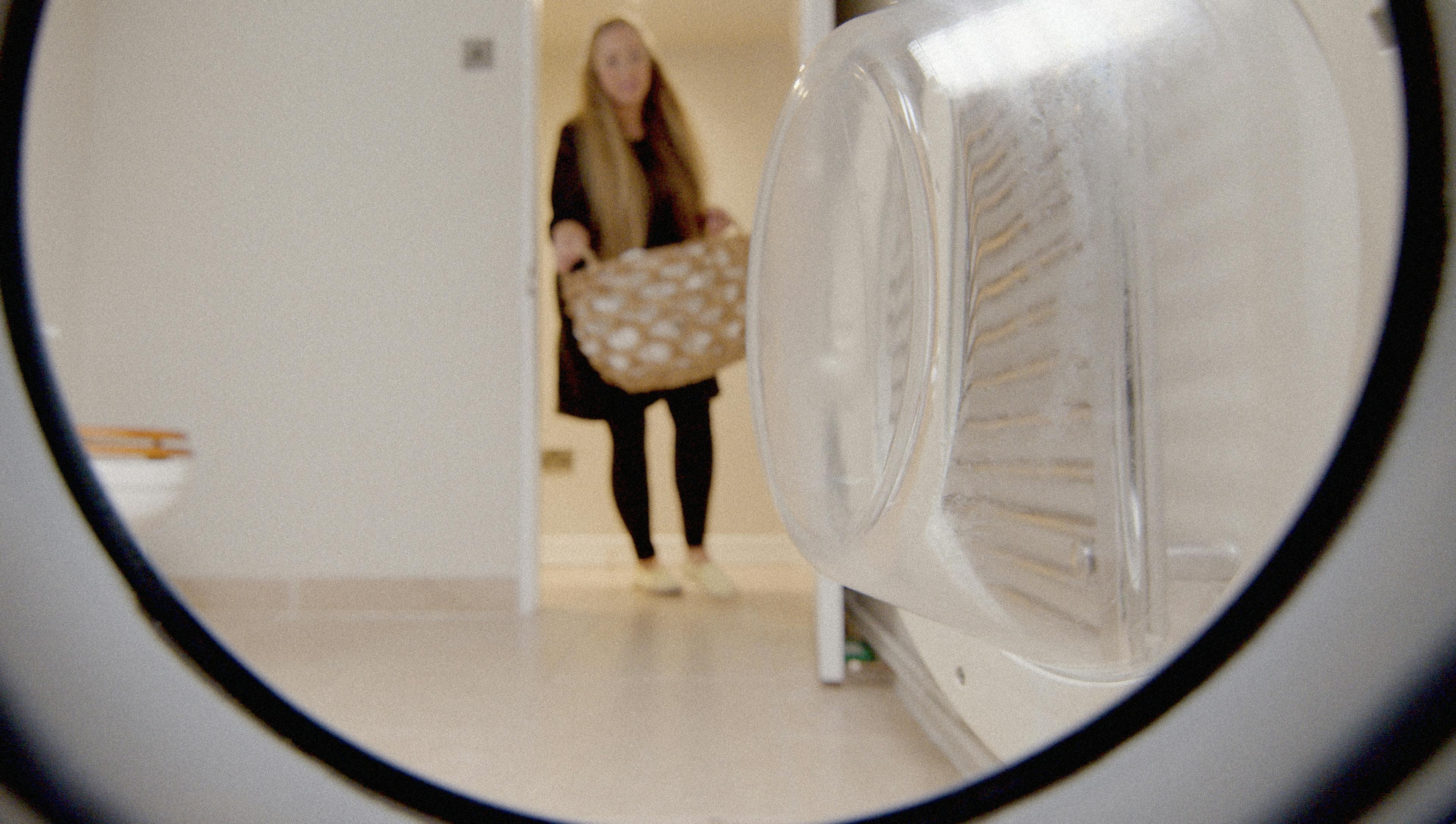 une femme faisant la lessive selon le point de vue d'une lave-linge