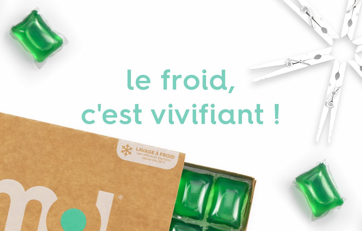 le texte "le froid, c'est vivifiant !" entourée d'un pack de capsules de lessive active au tiroir ouvert révélant des capsules, des capsules vertes et des pinces à linge blanches en forme de flocton de neige