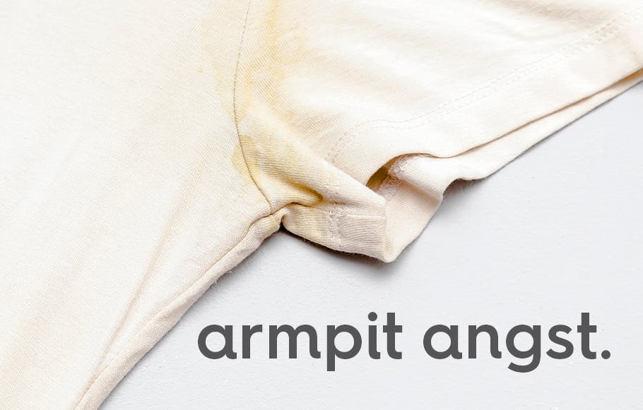white t-shirt with yellow stains on sleeve and text. text: armpit angst.